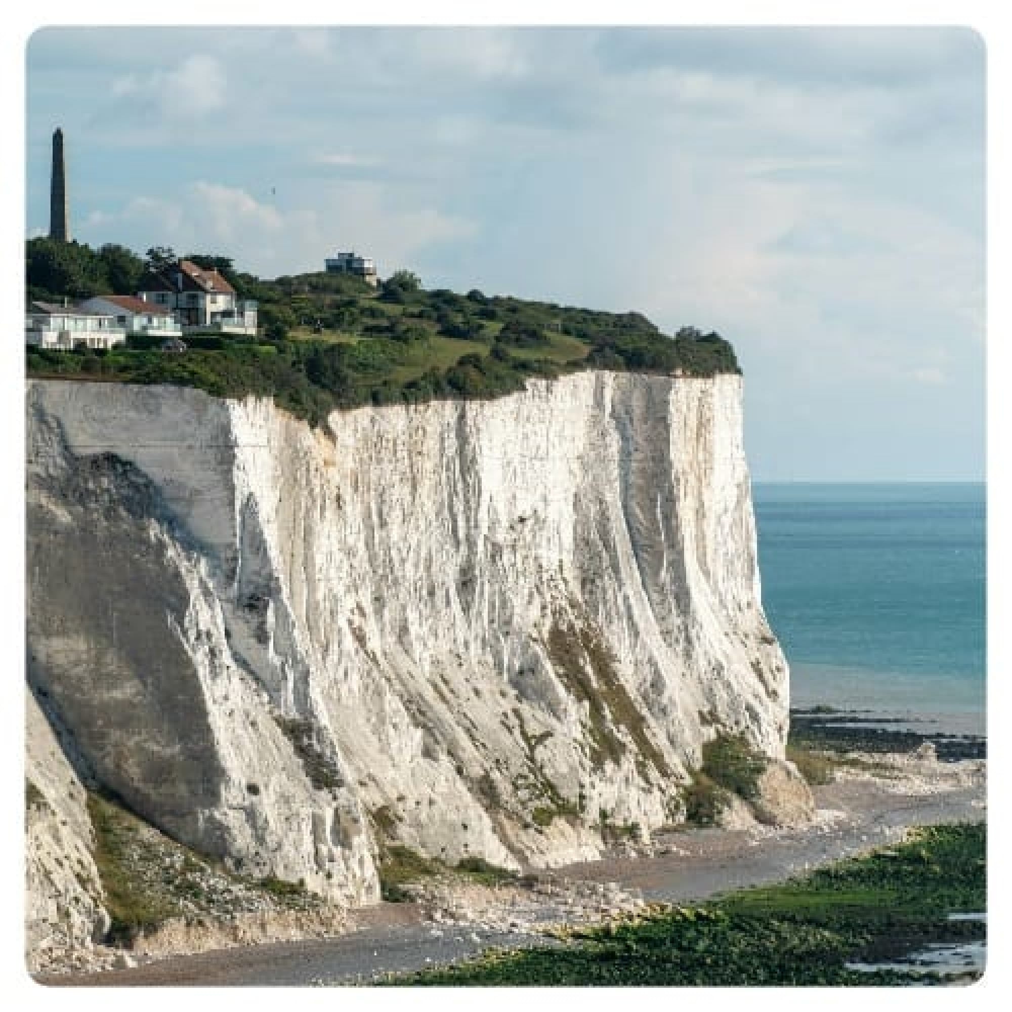 white and green cliff near sea during daytime