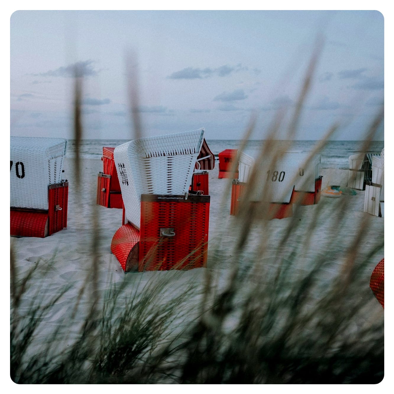 red and white beach baskets on white sandy beach