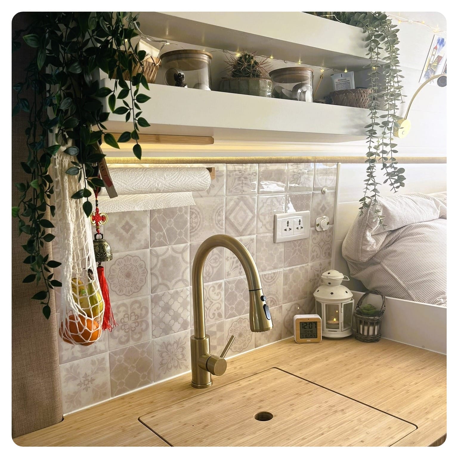 van life kitchn area with bamboo counter top and beige pattered wall tiles and brushed gold tap