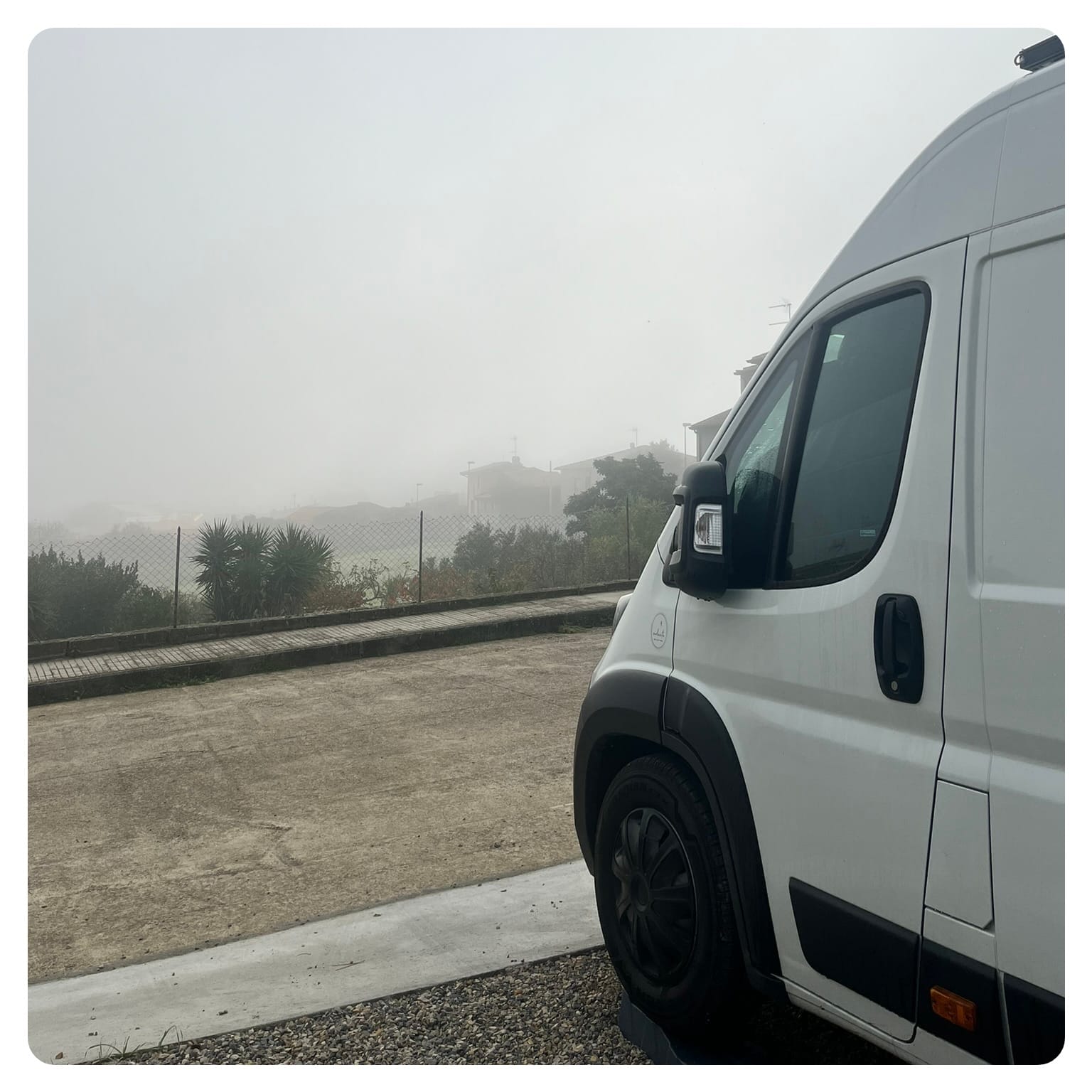 white Fiat Ducato camper van in fog cloud in Sardinia