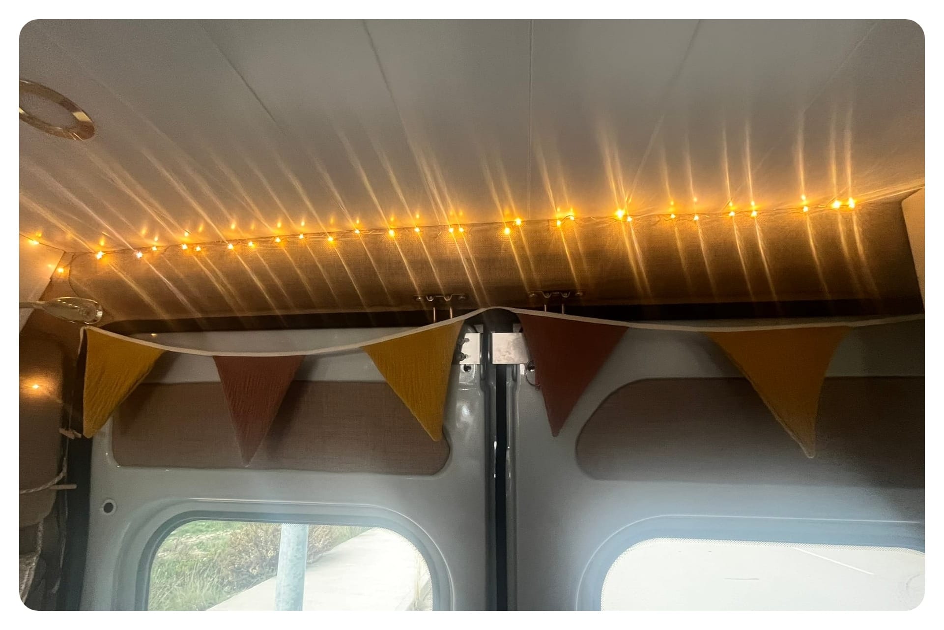 van life door area with mustand yellow and beige cotton bunting and fairy lights