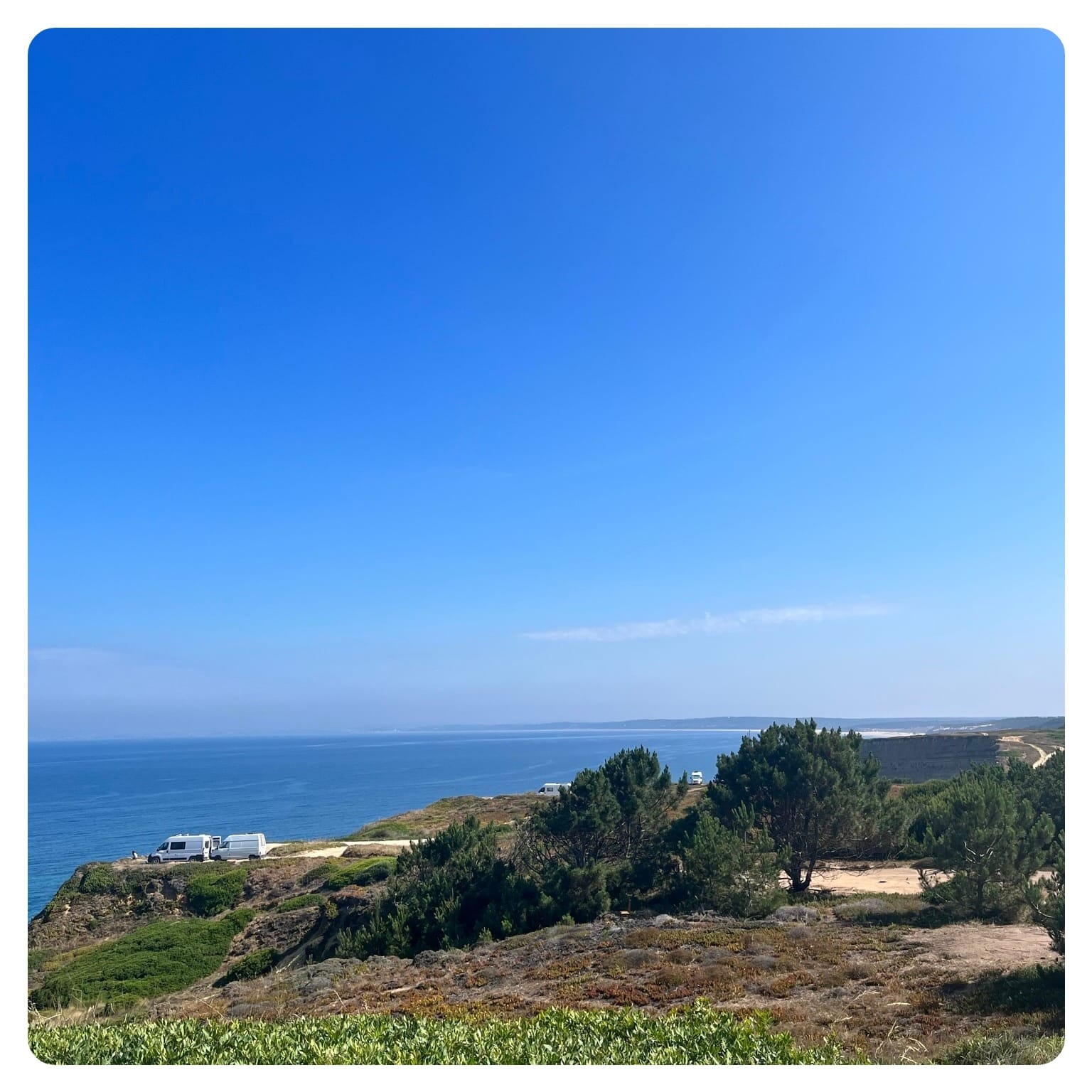 vanlavita white camper van on cliff side overlooking the sea in Portugal