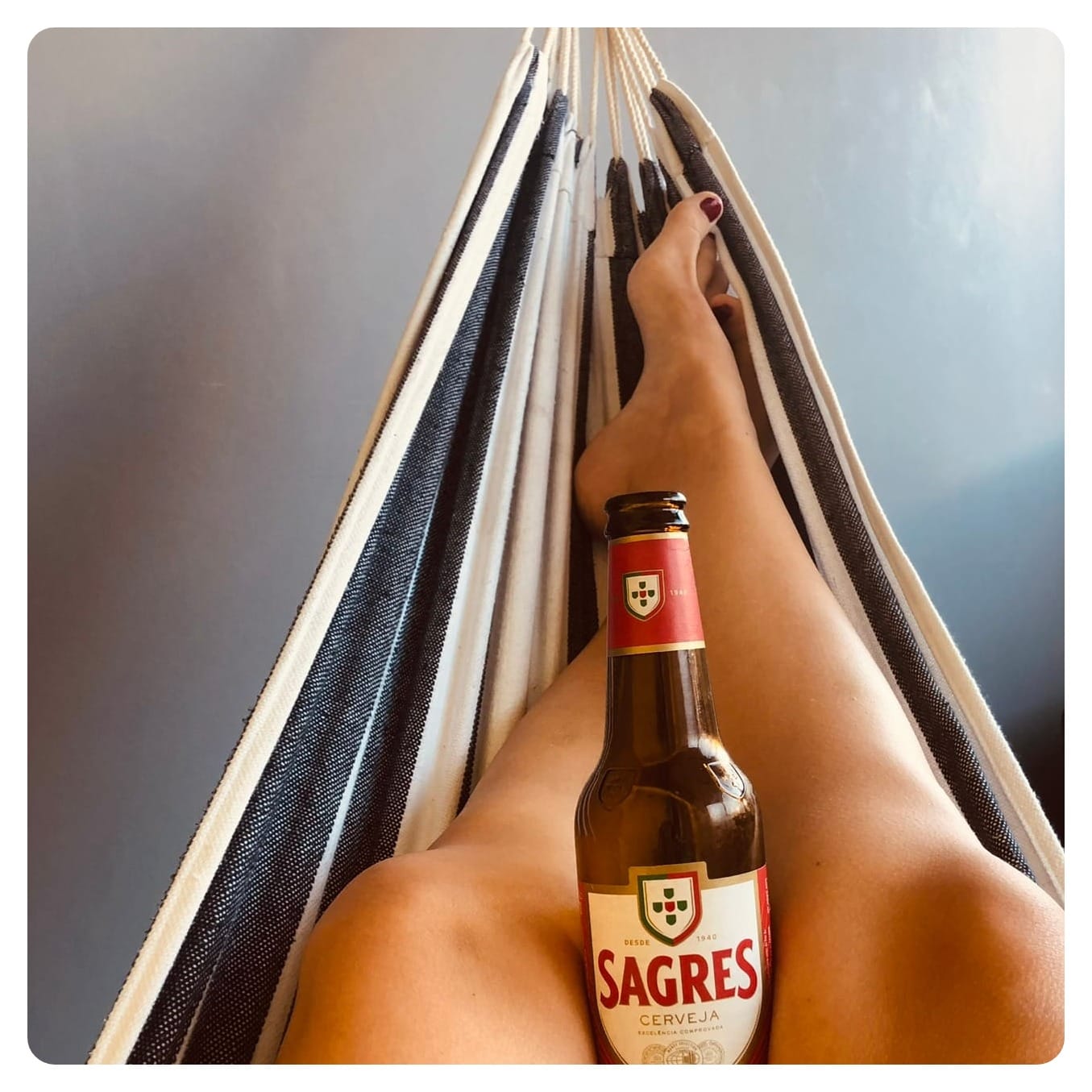vanlavita woman with legs on hammock with Sagres beer in Faro, Portugal