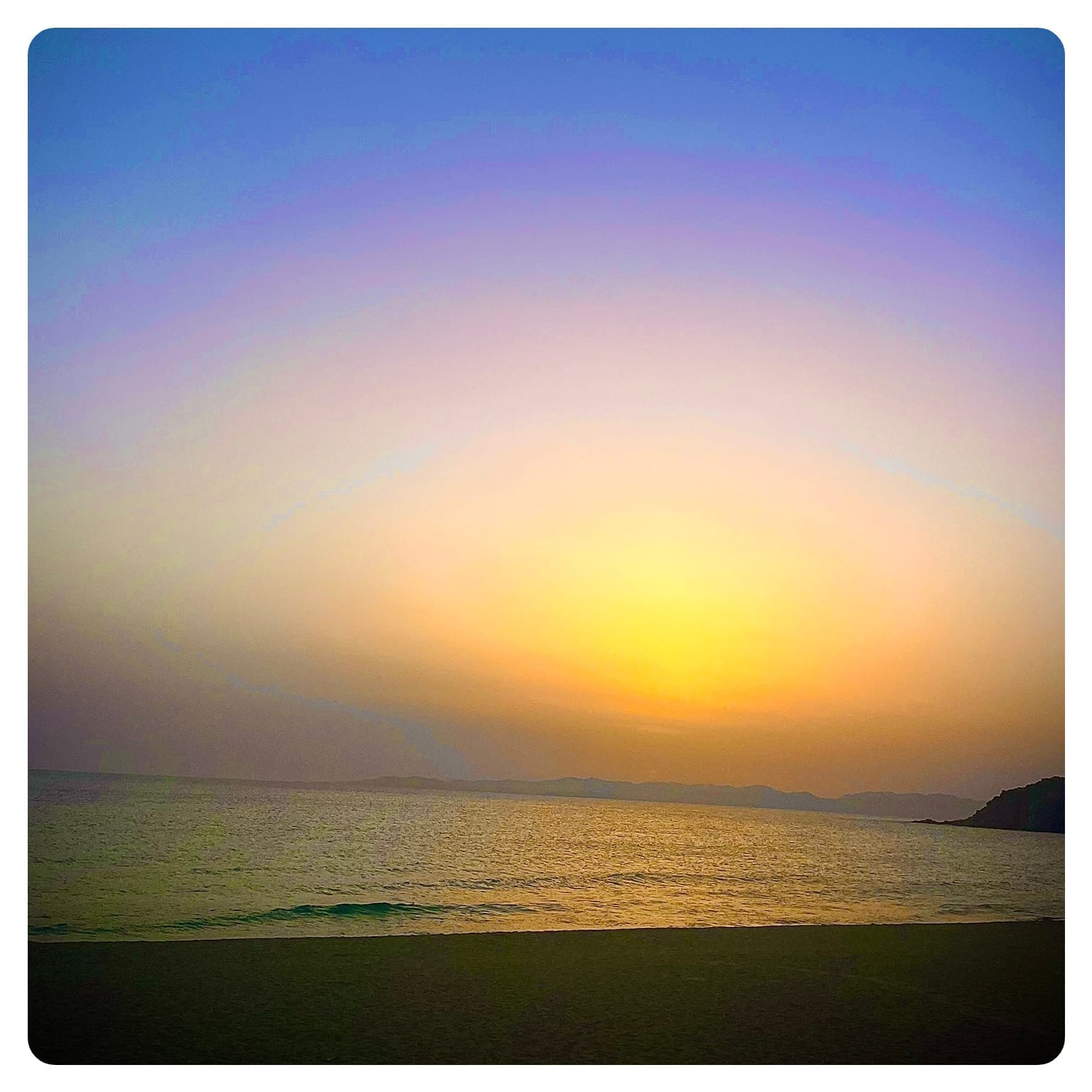 orange and purple sunset scene from beside a beach