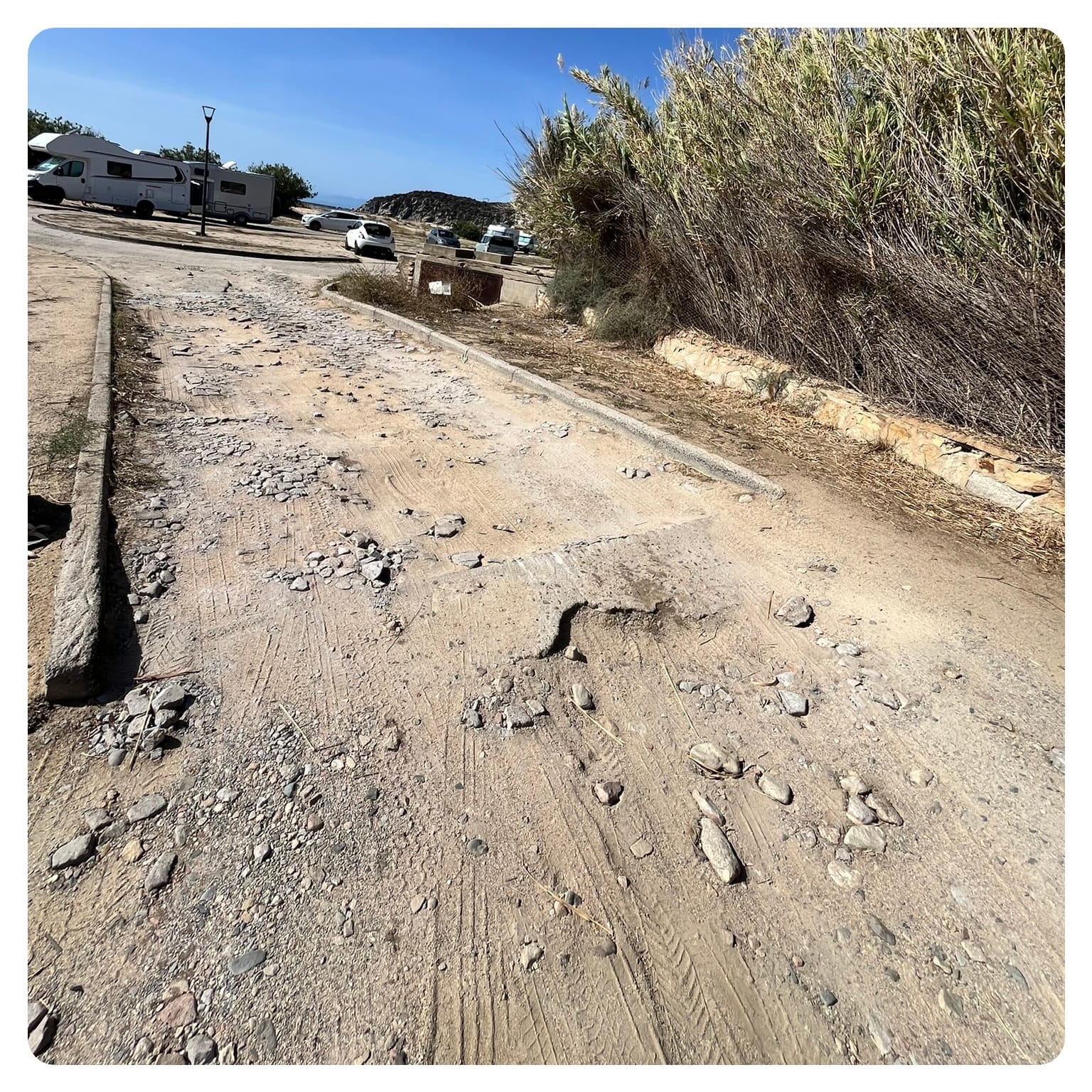 unpaved and potholed road in bad condition
