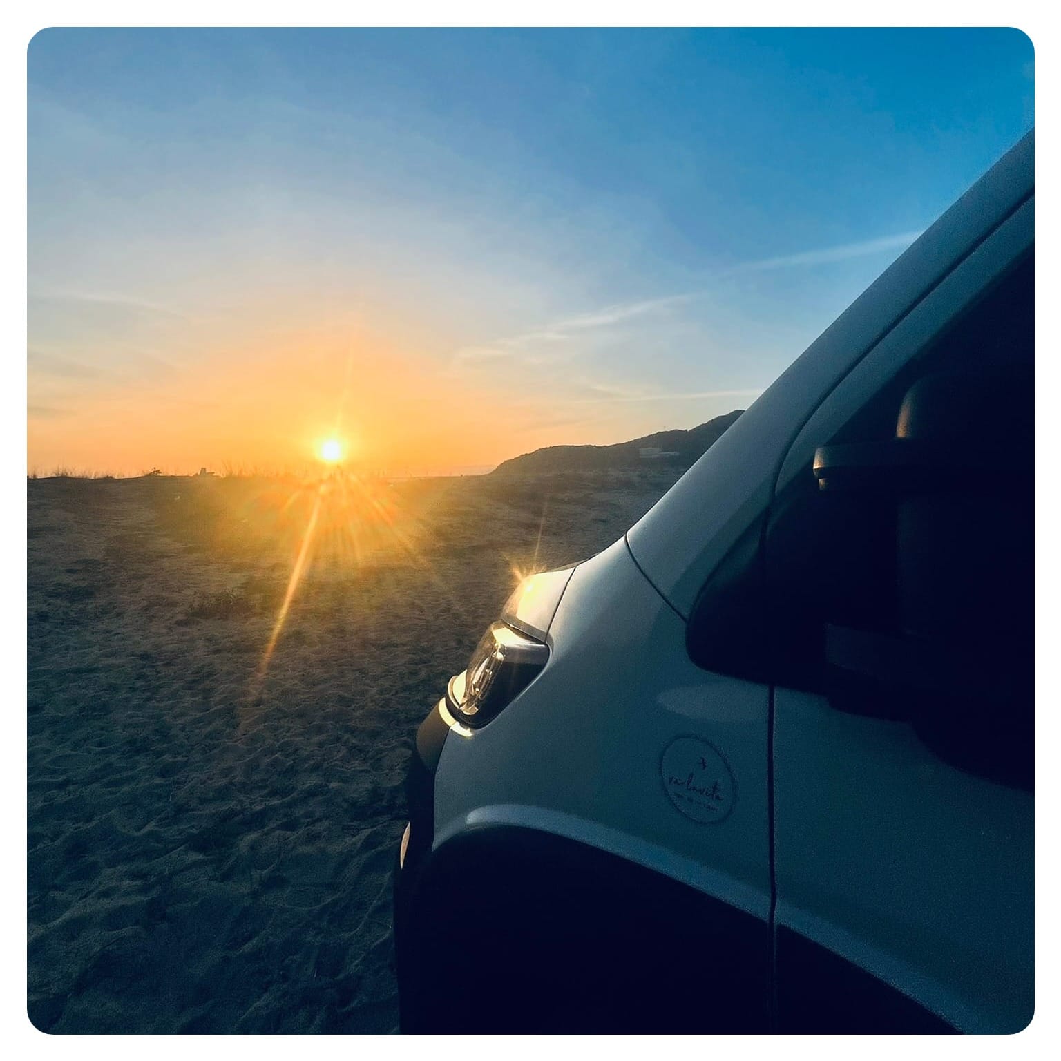 van life vanlavita van parked on beach with sunset in the background