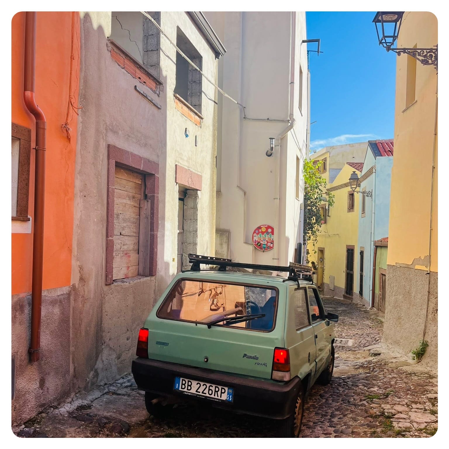 Fiat Panda car driving through narrow cobbled streets in Bosa