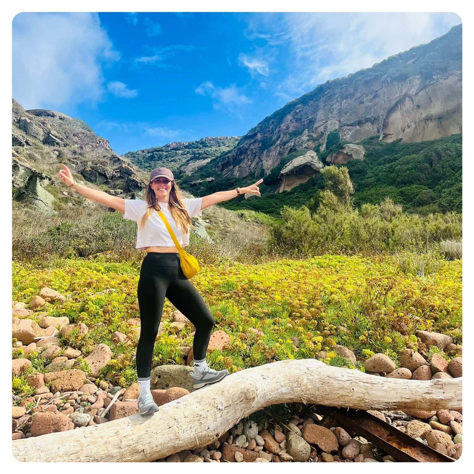 van life vanlavita woman standing on fallen tree trunk with arms in the air