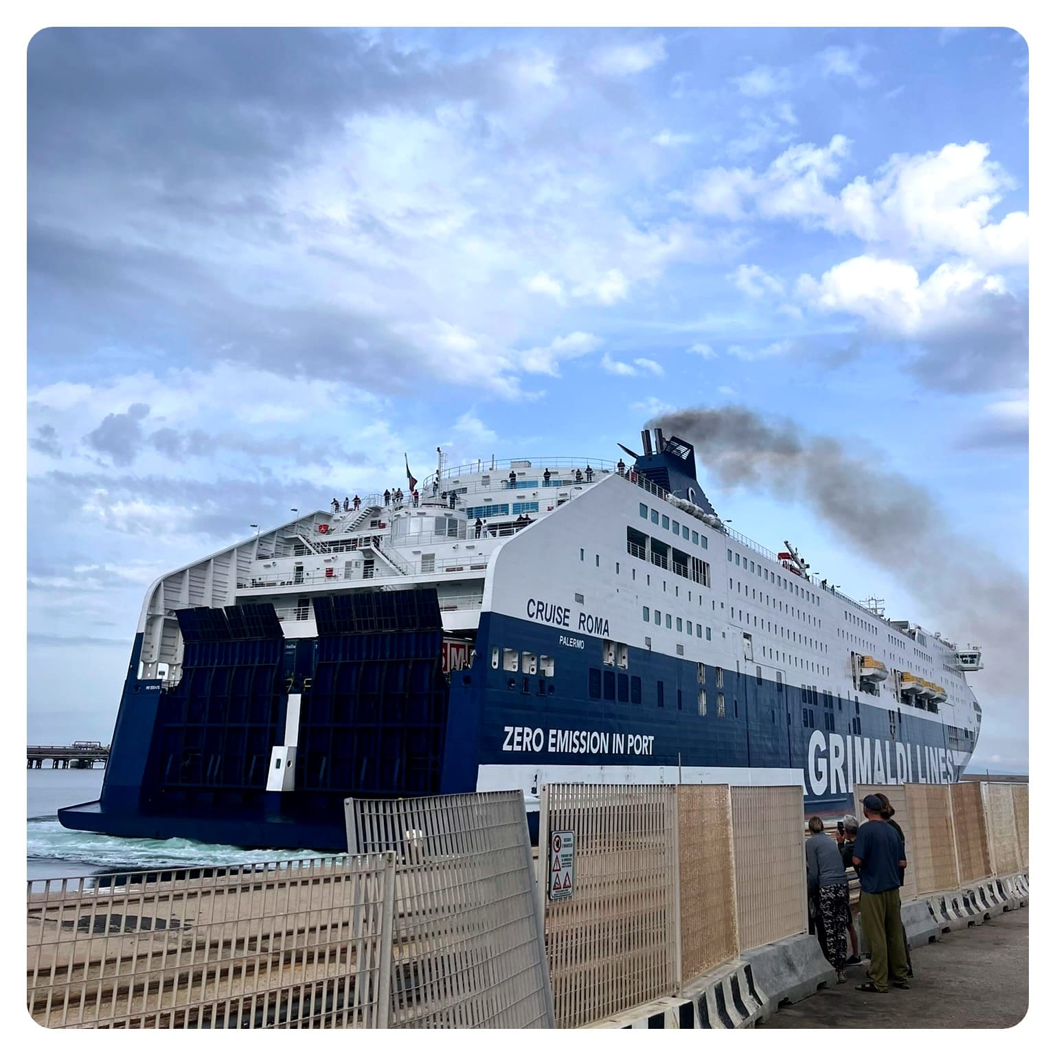 large blue and white ferry of Grimaldi Lines pulling into a port