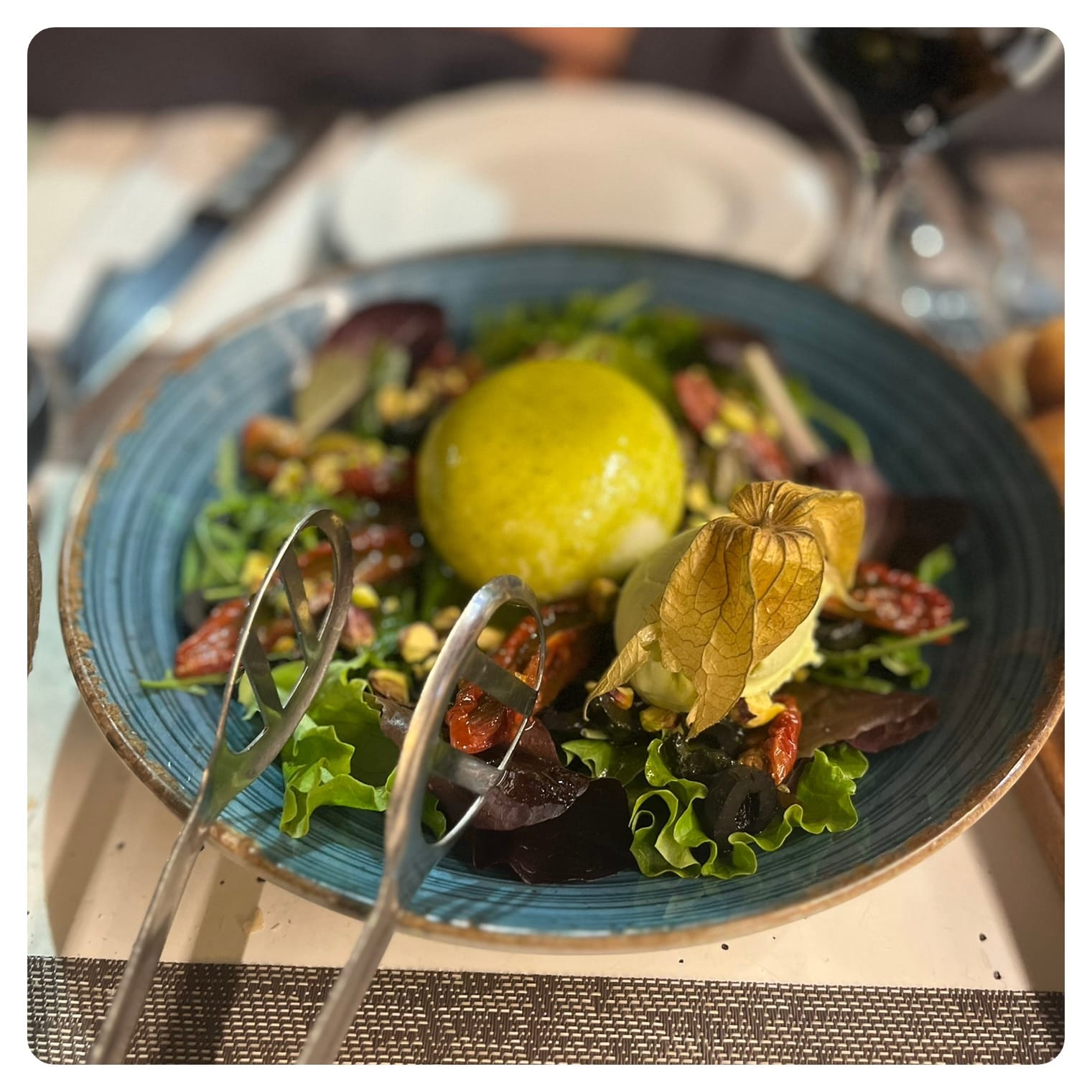 buratta salad served in turqouise blue bowl