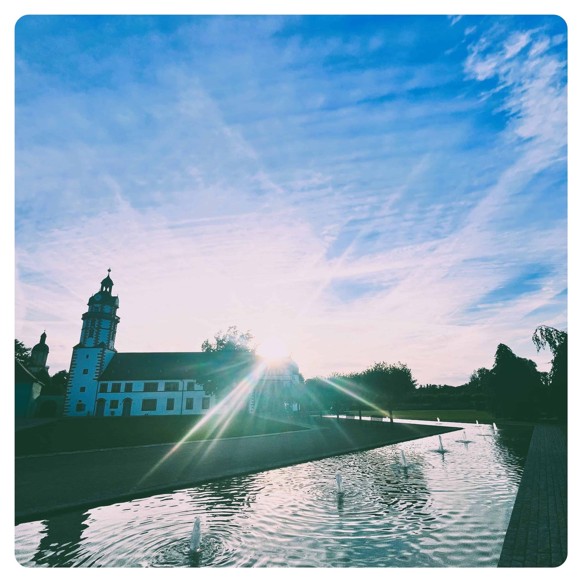 white castle with black roof in from of water fountains in Ohrdruf, Germany