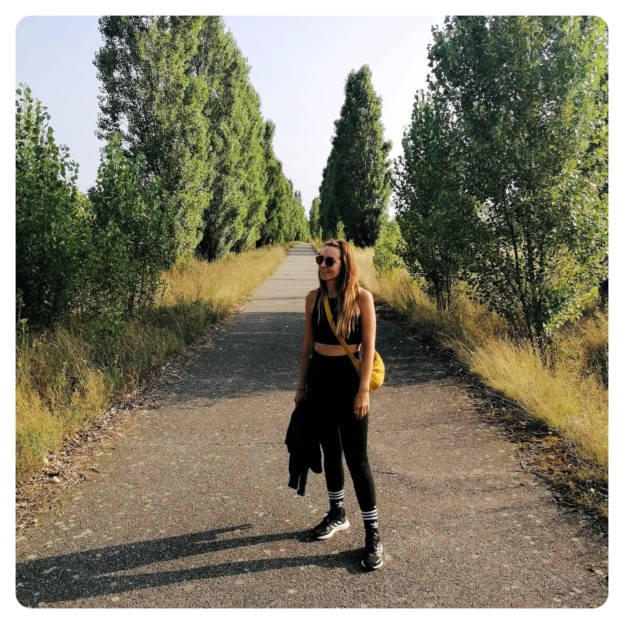 vanlavita woman walking on countryside lane with trees