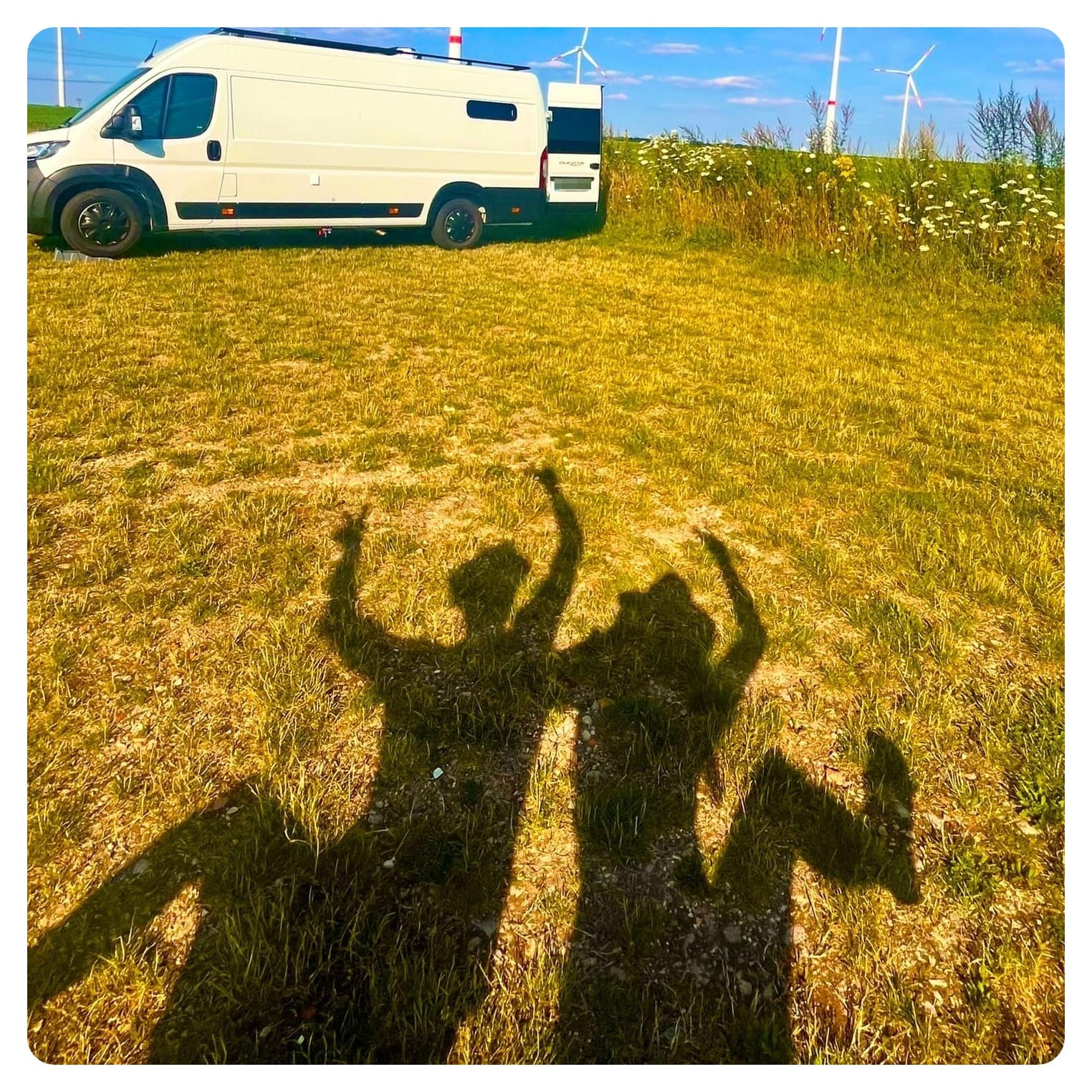 vanlife vanlavita woman and woman making shadow shapes on grass in the sunshine