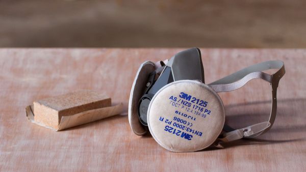 A picture of a sanding block and a dust mask, tools that one uses when renovating.