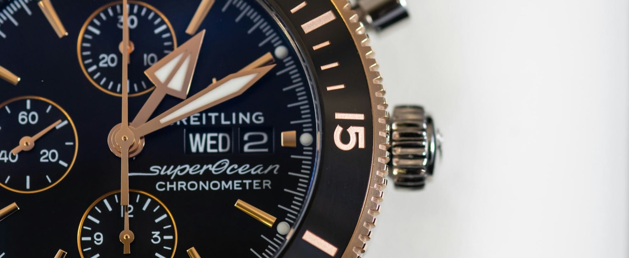 round black and gold-colored Brietling chronograph watch