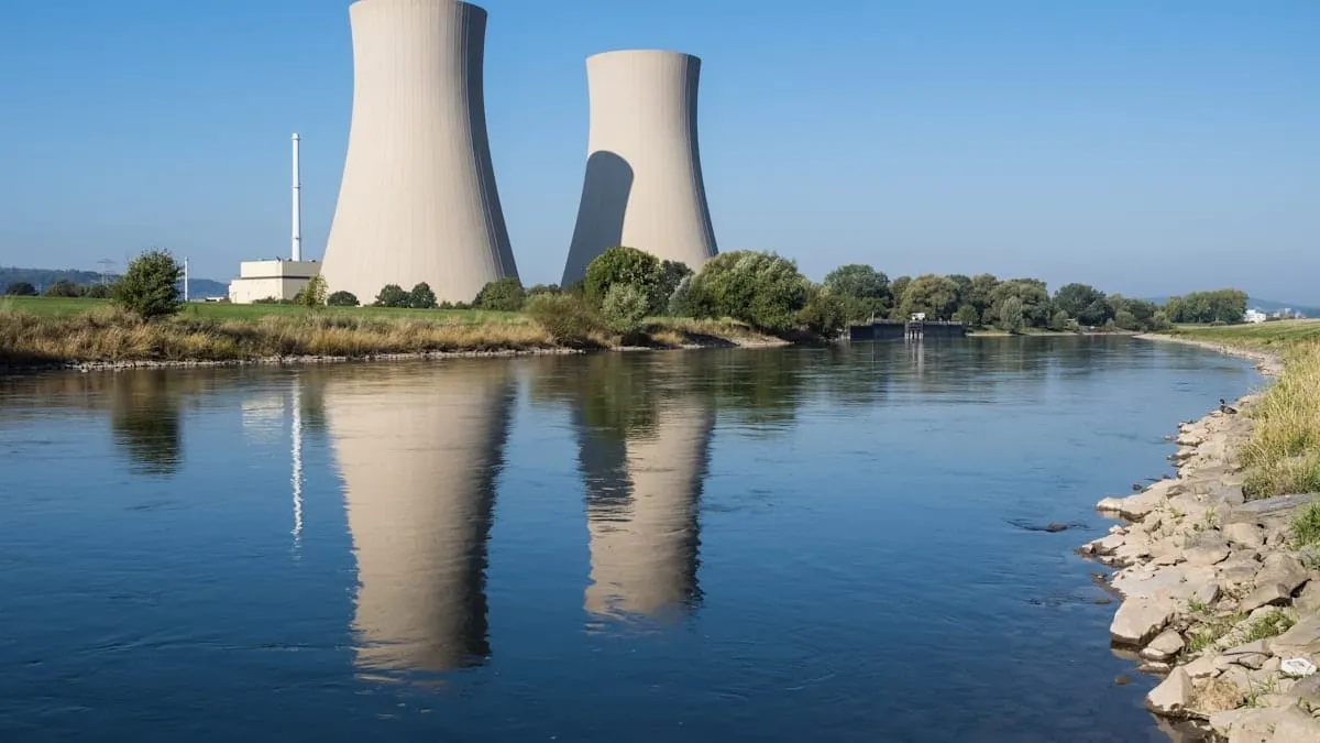 Torres de enfriamiento de una planta de energía junto a un cuerpo de agua