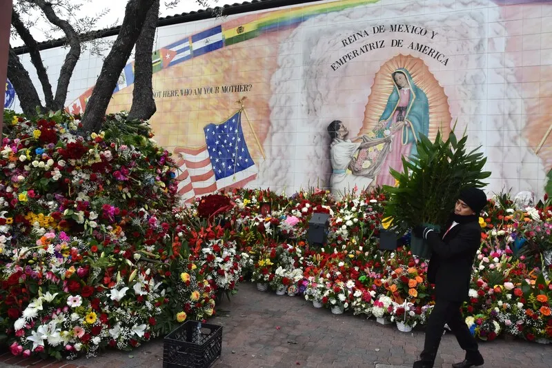 IDENTIDAD. Voluntario acomoda arreglos florales para la Virgen de Guadalupe en el centro histórico de Los Ángeles, California