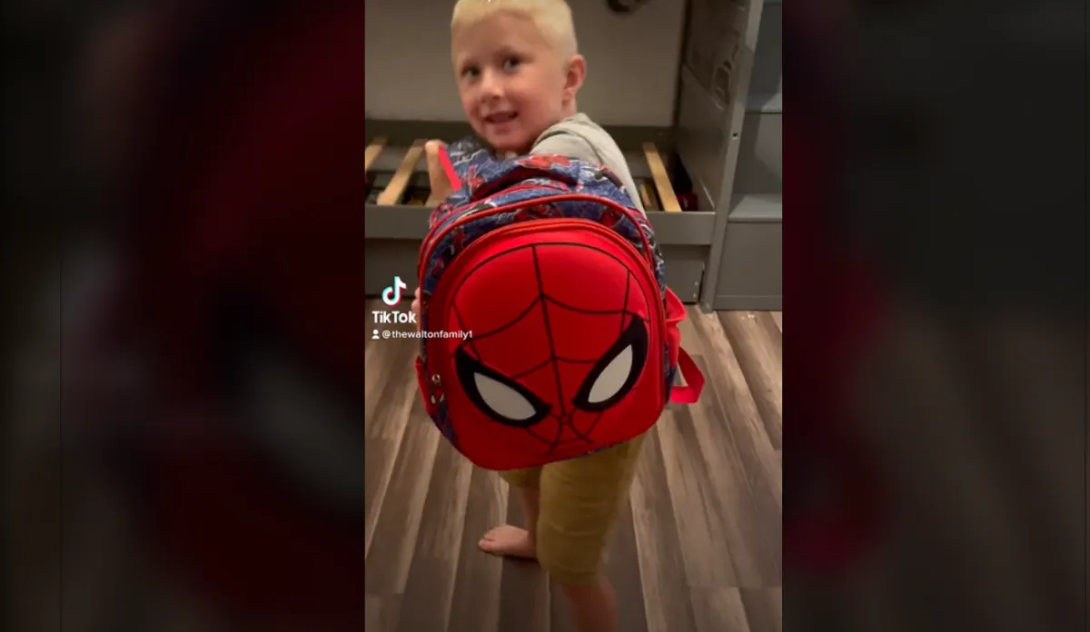 Madre que prepara a su hijo con mochila antibalas para el regreso a clases