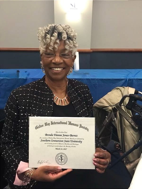 Brenda Dianne Jones-Barnes smiling while holding a Golden Key International Honour Society certificate at Southern Connecticut State University in 2017