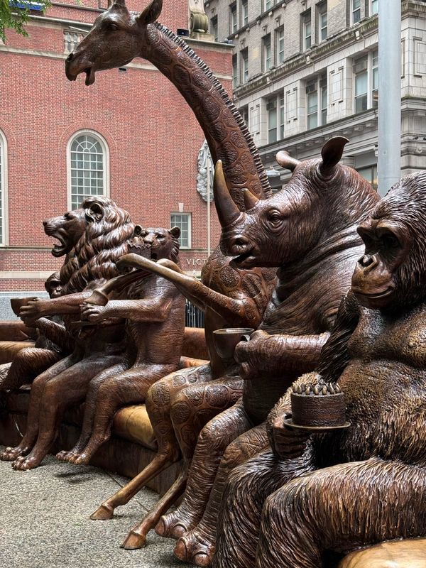 Bronze wildlife sculptures from Gillie and Marc's The Wild Couch Party installation in New York City, featuring a lion, rhino, giraffe, gorilla, and other endangered animals gathered together