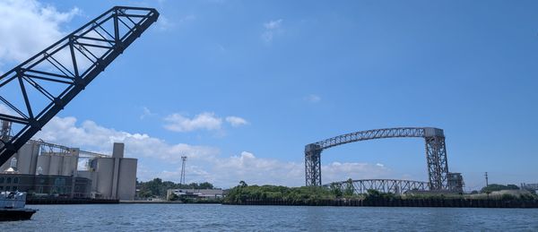 The Cuyahoga river where it meets Lake Erie, featuring two historic steel bridges. Summer day, blue sky.