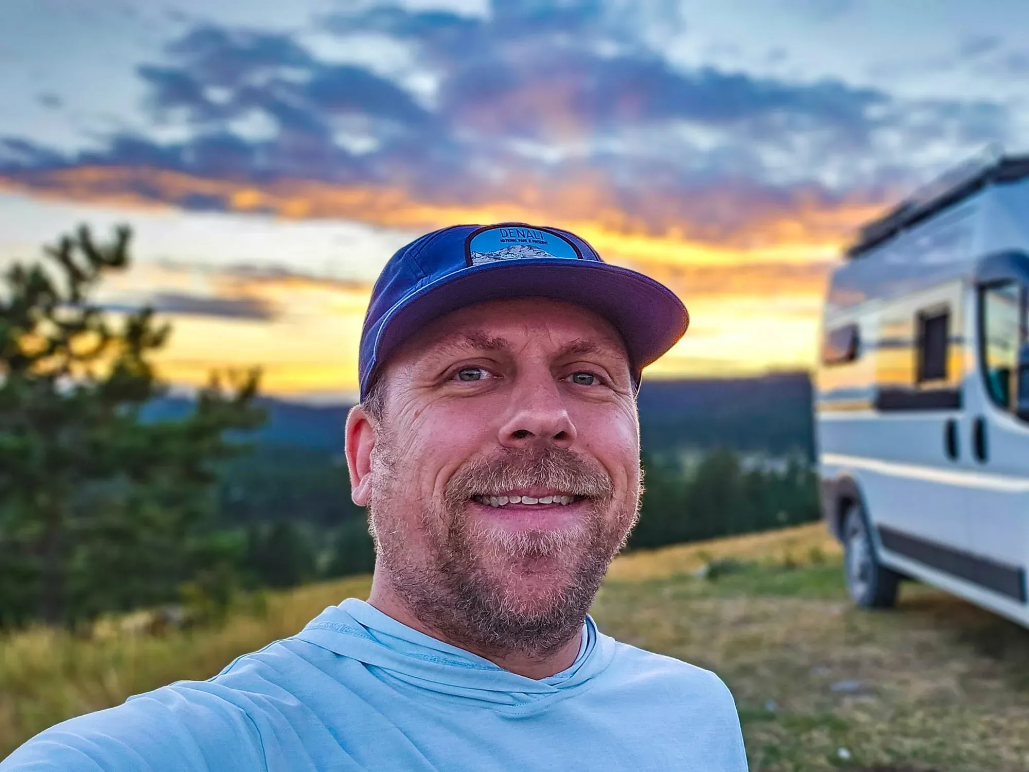 Eric Kufrin, Yosemite guide, at camp during golden hour with van Sierra in background