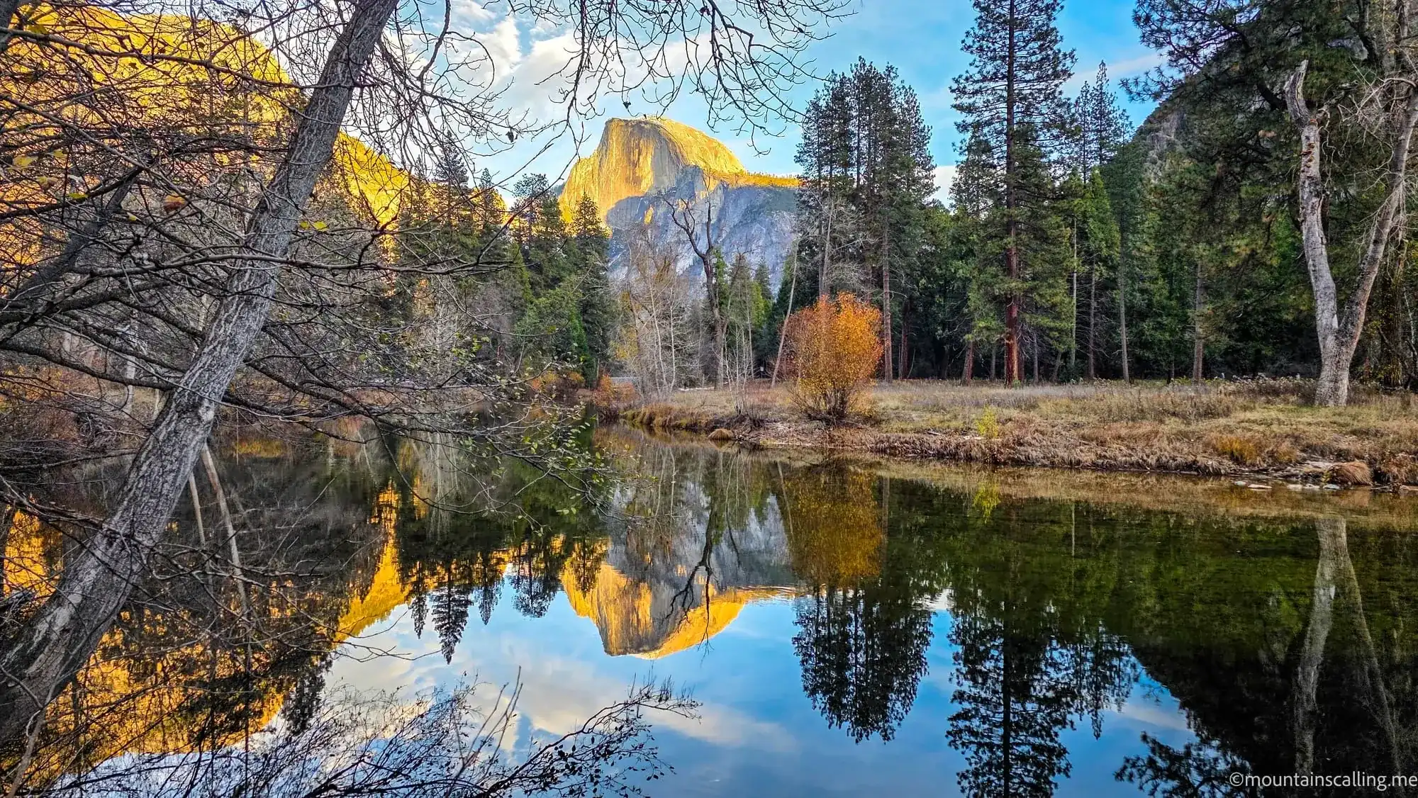 Half Dome and Yosemite Valley autumn reflection in Merced River with golden light on granite cliffs