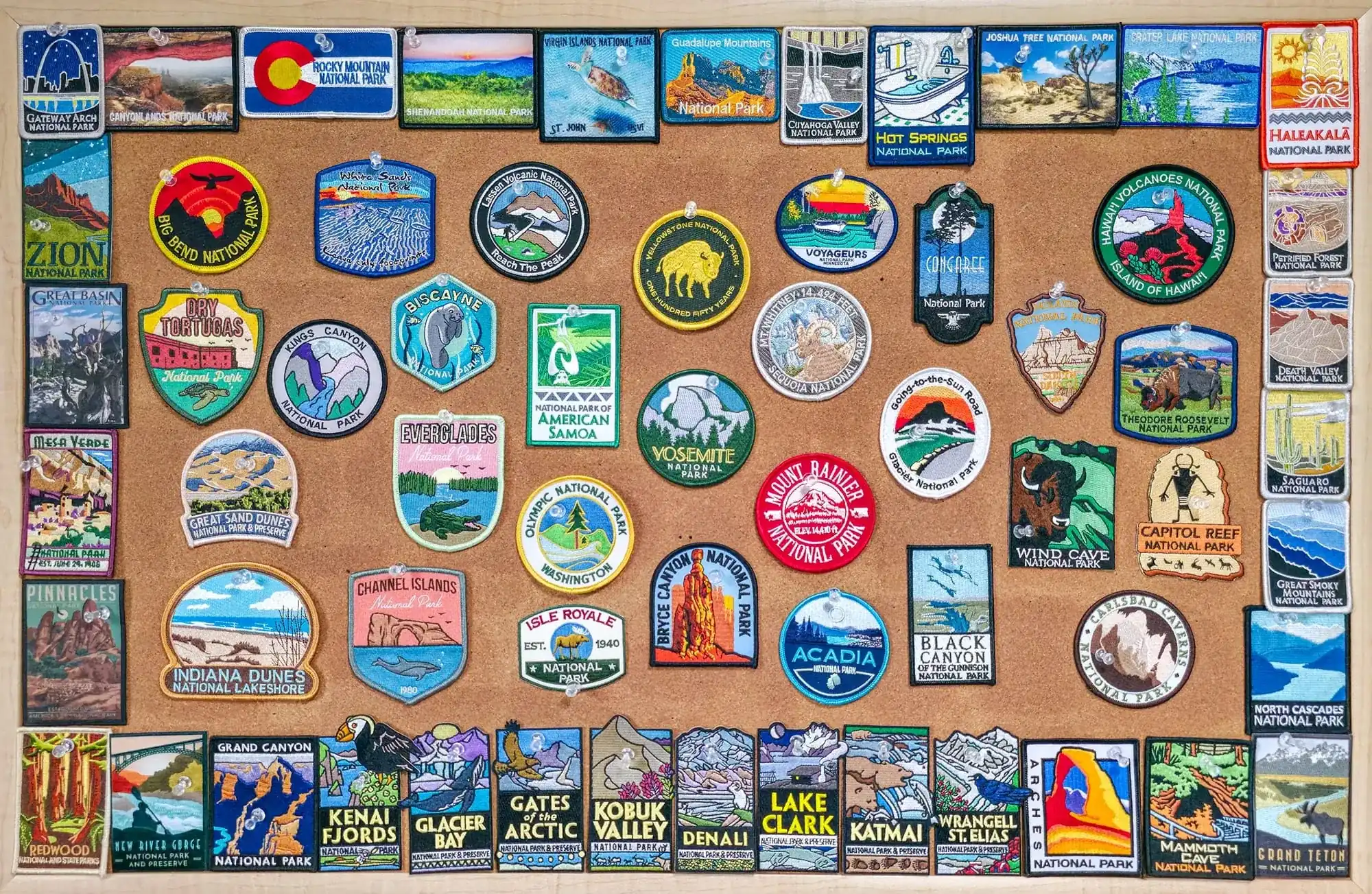 Collection of patches from all 63 U.S. National Parks displayed on cork board including Yosemite, Yellowstone, Grand Canyon