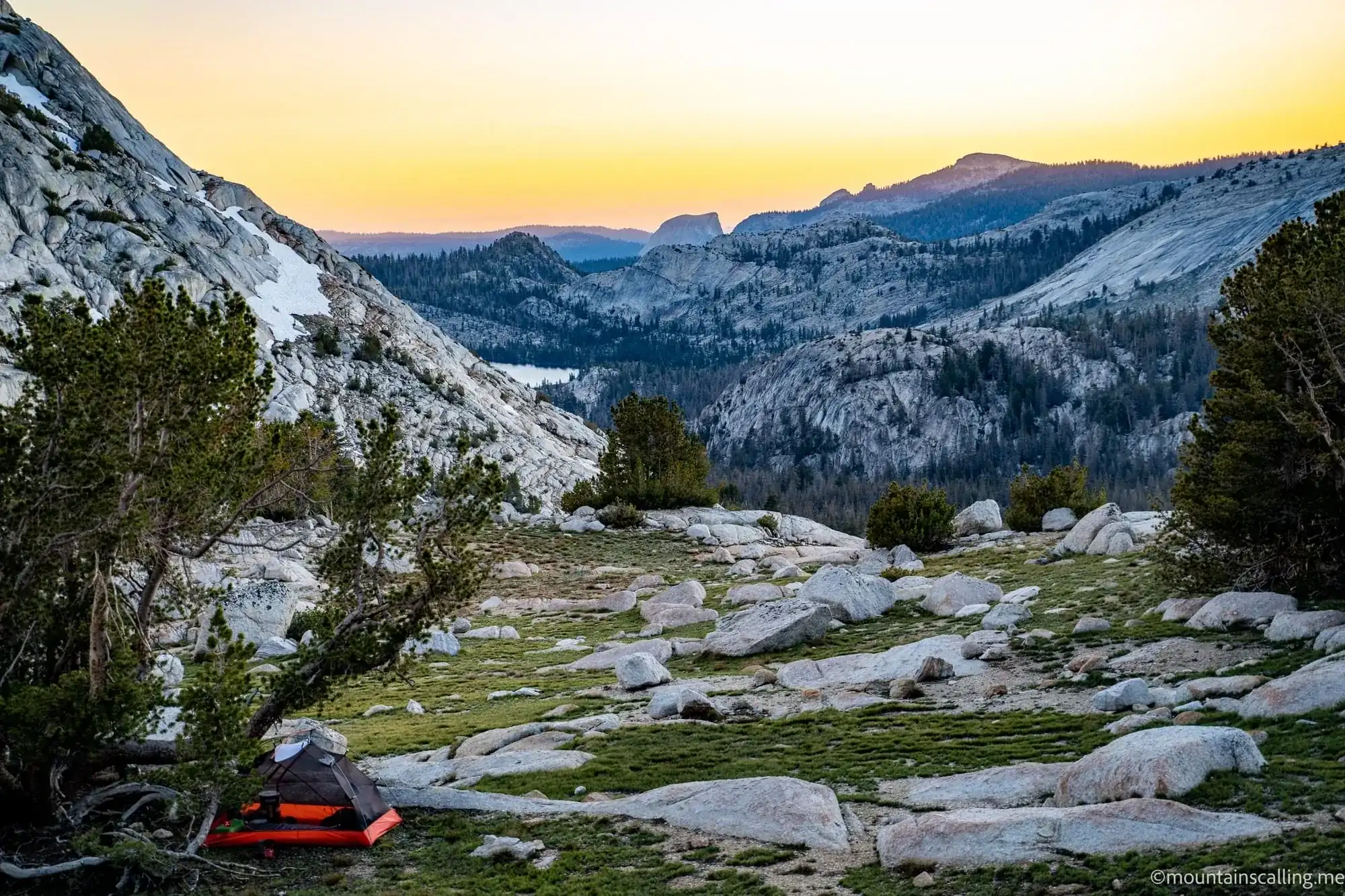 Backpacking tent at sunset campsite overlooking granite peaks on guided Yosemite wilderness trip