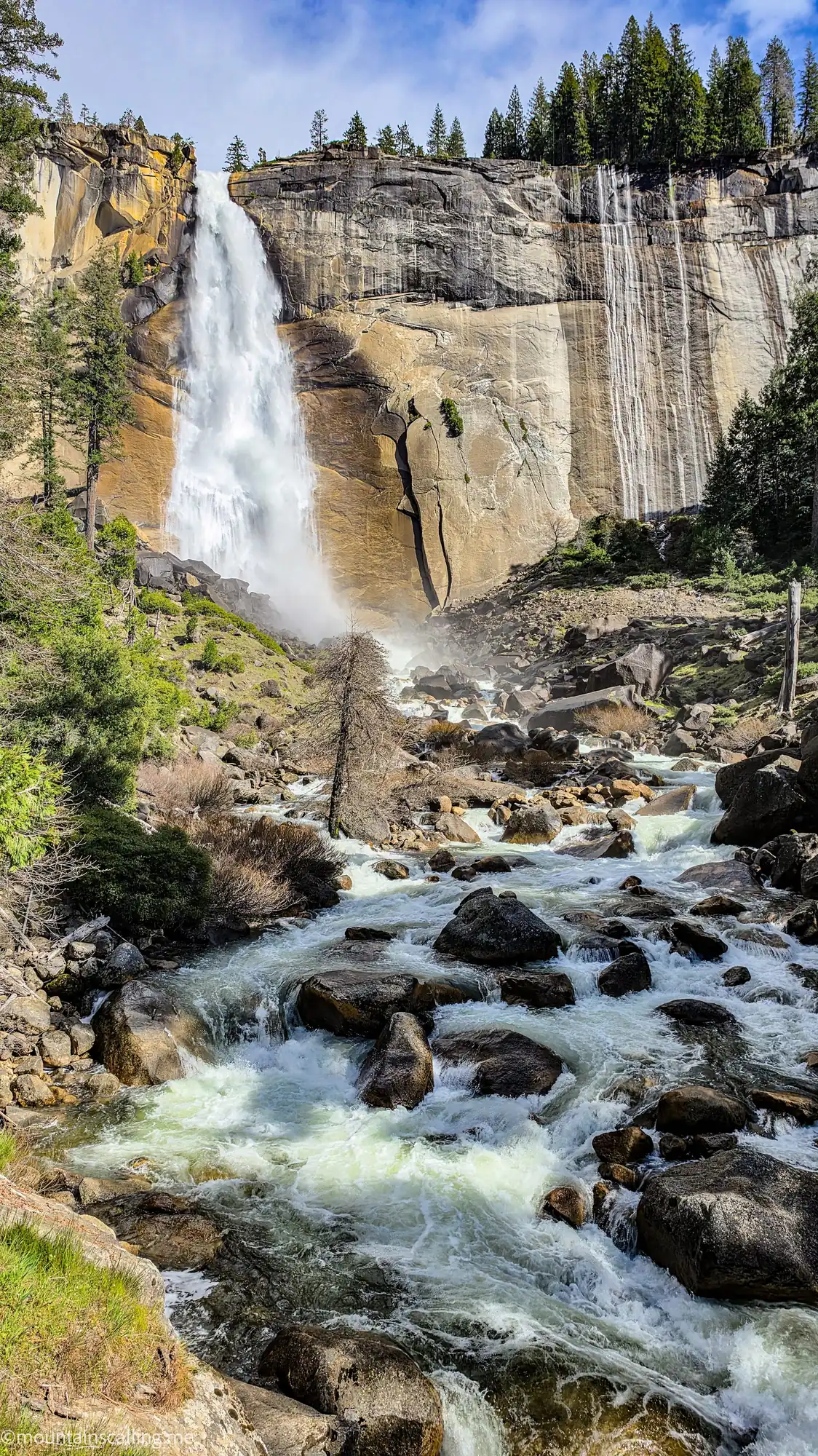 Waterfall cascading over granite cliff with rushing stream on Clouds Rest backpacking route