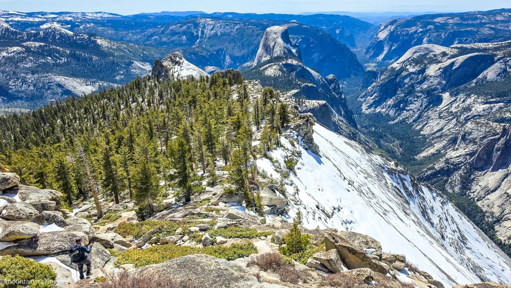 Snow-covered granite slopes and Half Dome from Clouds Rest backpacking trail in Yosemite's high country