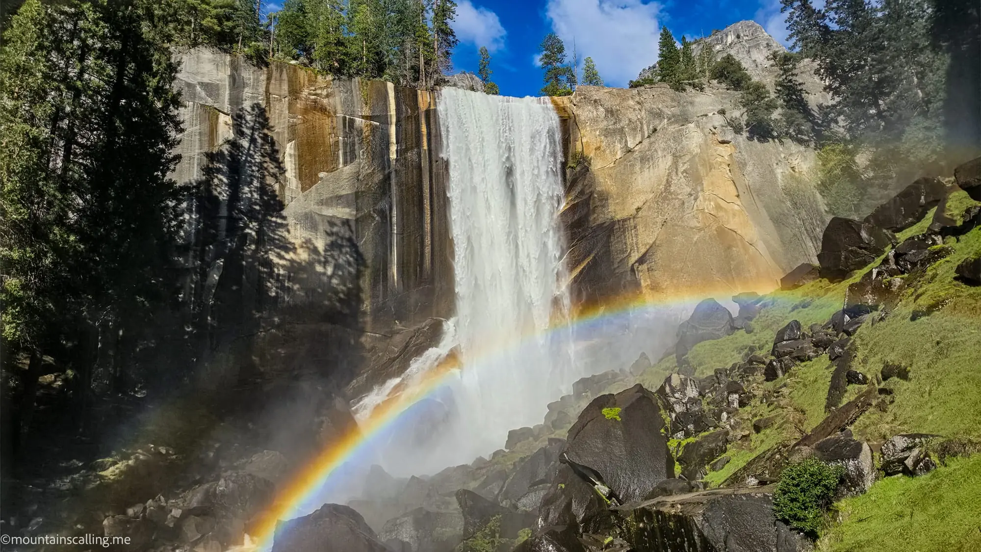 Rainbow in waterfall mist on Clouds Rest backpacking trail during spring snowmelt