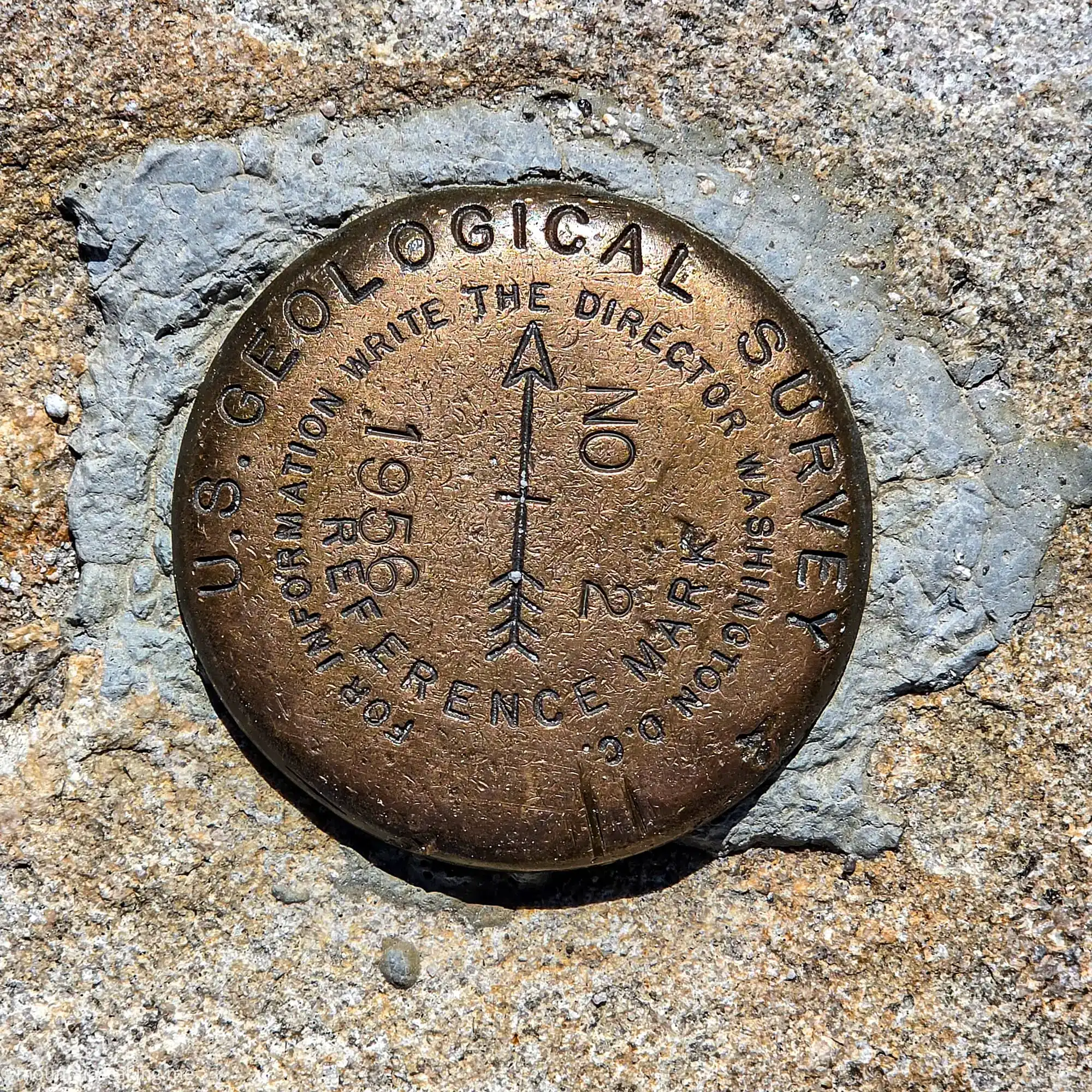USGS geological survey benchmark marker embedded in granite on Clouds Rest summit trail