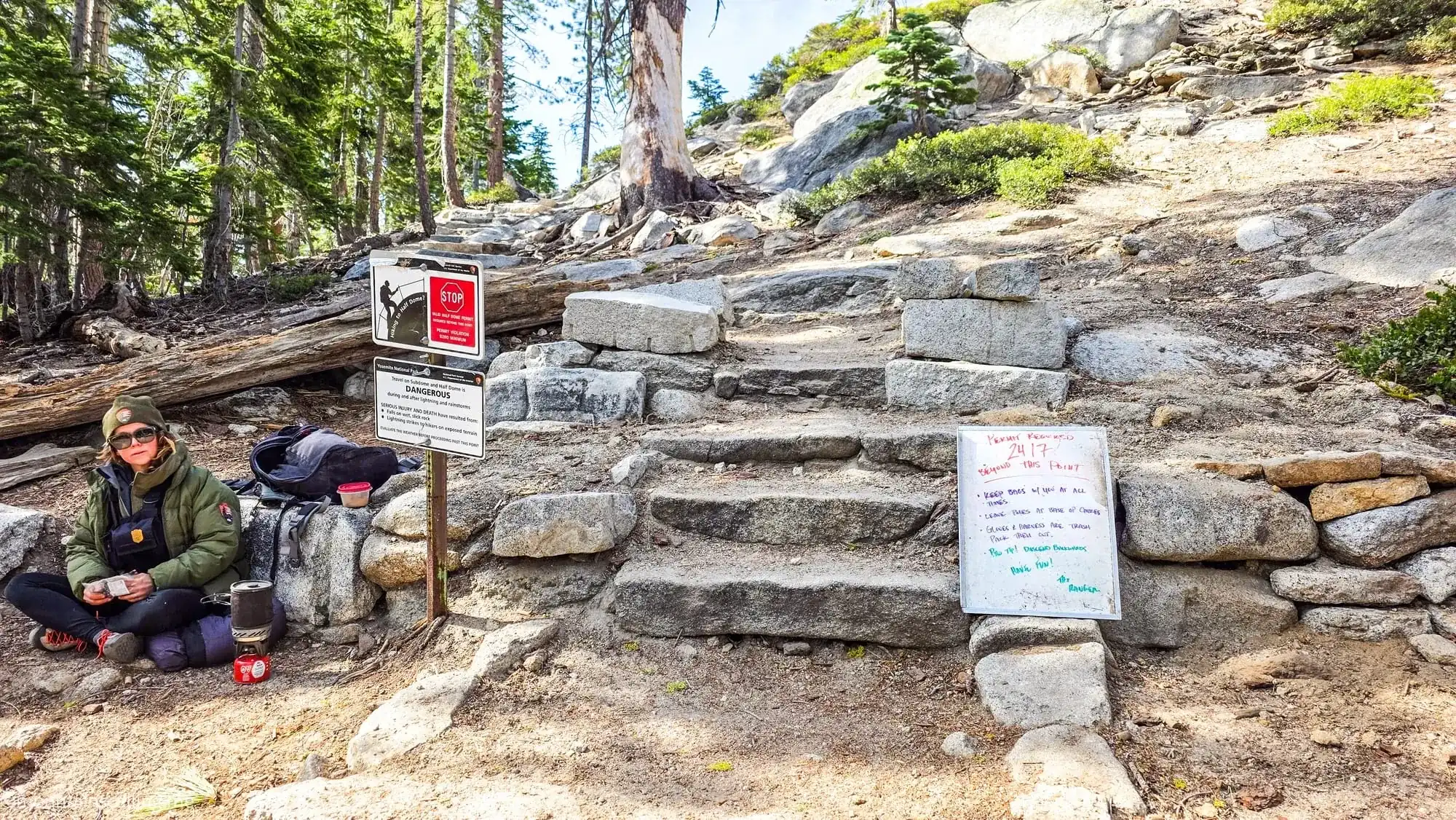 NPS Park ranger checking Half Dome permits at Sub Dome checkpoint with permit inspection signs