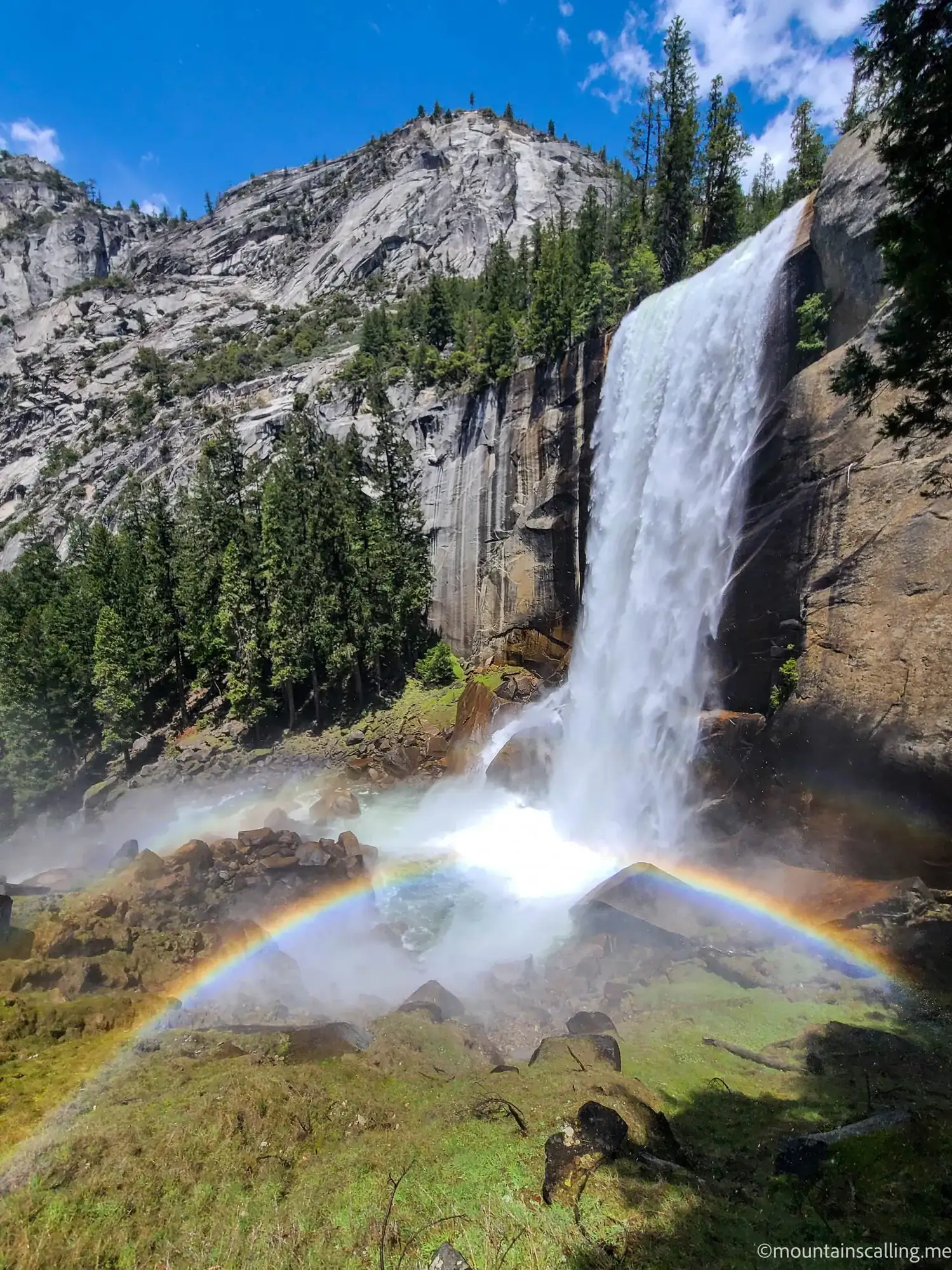 Vernal Fall on the Mist Trail with double rainbow formed in spray at base, granite cliffs and pine forest visible