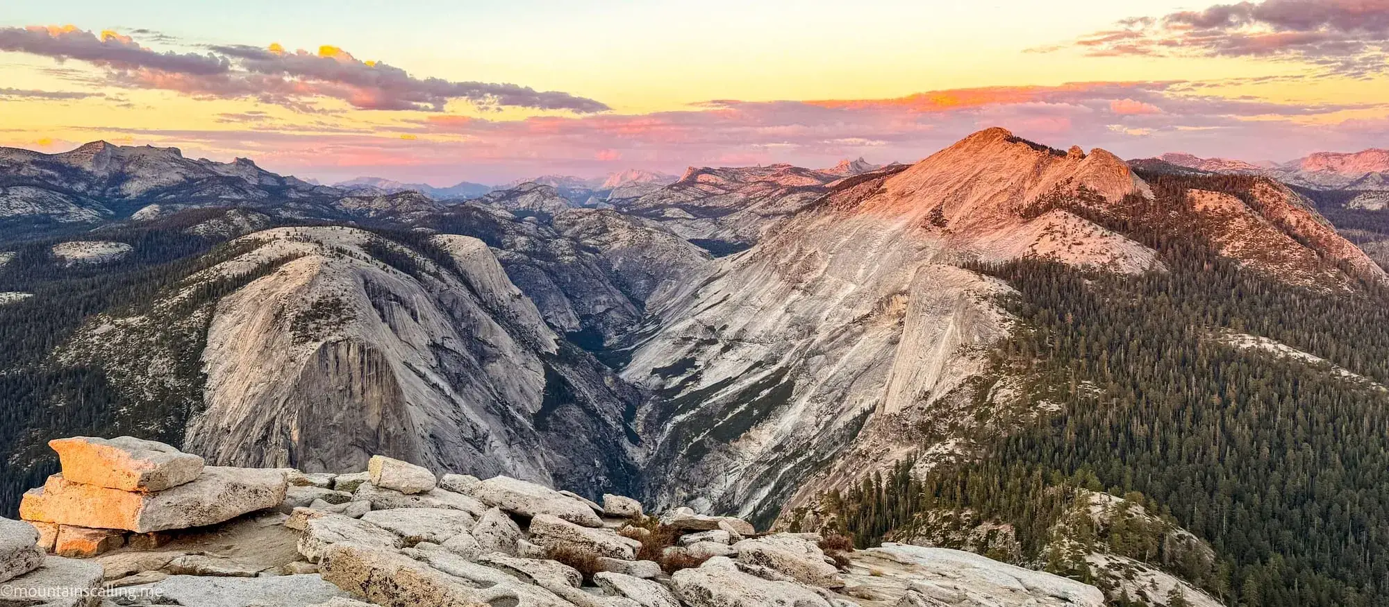 Sunset alpenglow on granite domes and peaks from high country viewpoint in Yosemite backcountry wilderness