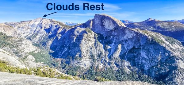 Clouds Rest and Half Dome seen from across Yosemite's high country, with Clouds Rest's broad granite summit on the left and Half Dome's iconic profile on the right against a blue sky