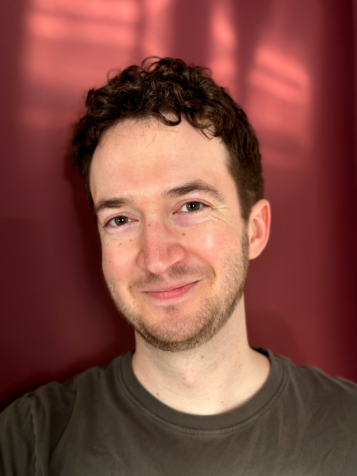 A headshot of Willys DeVoll wearing a dark green shirt