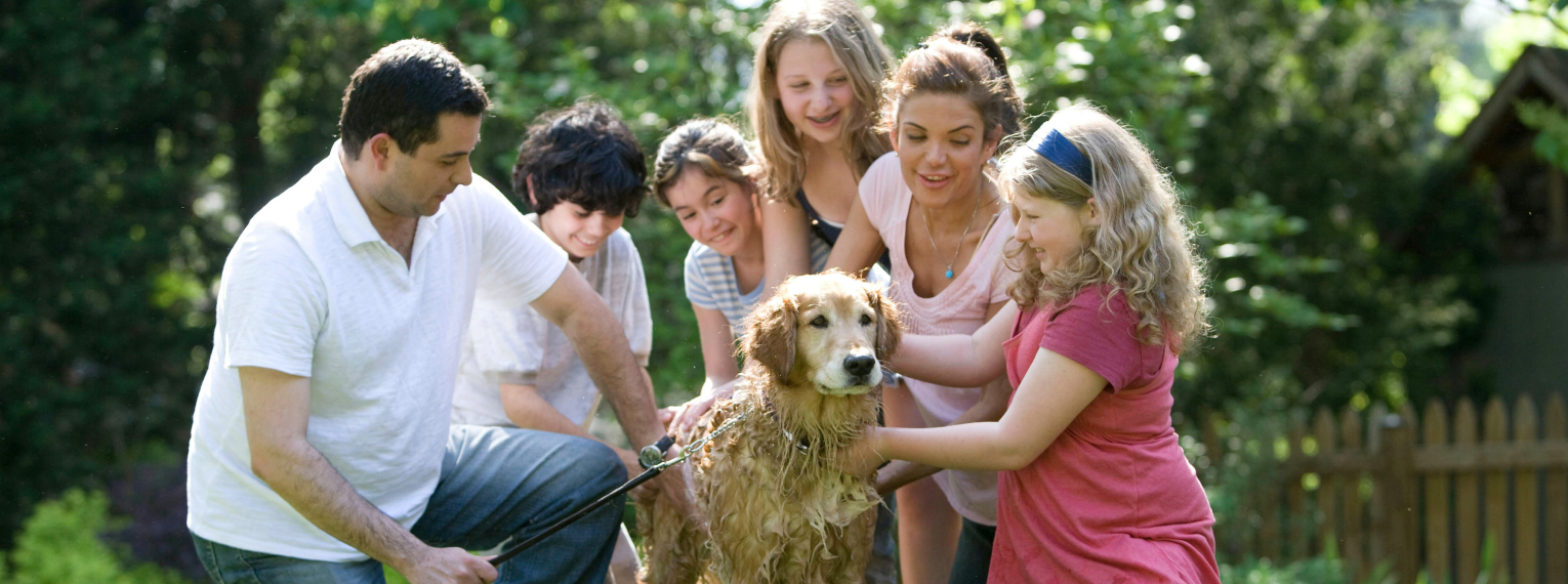Eine Familie mit ihrem Hund im Garten.