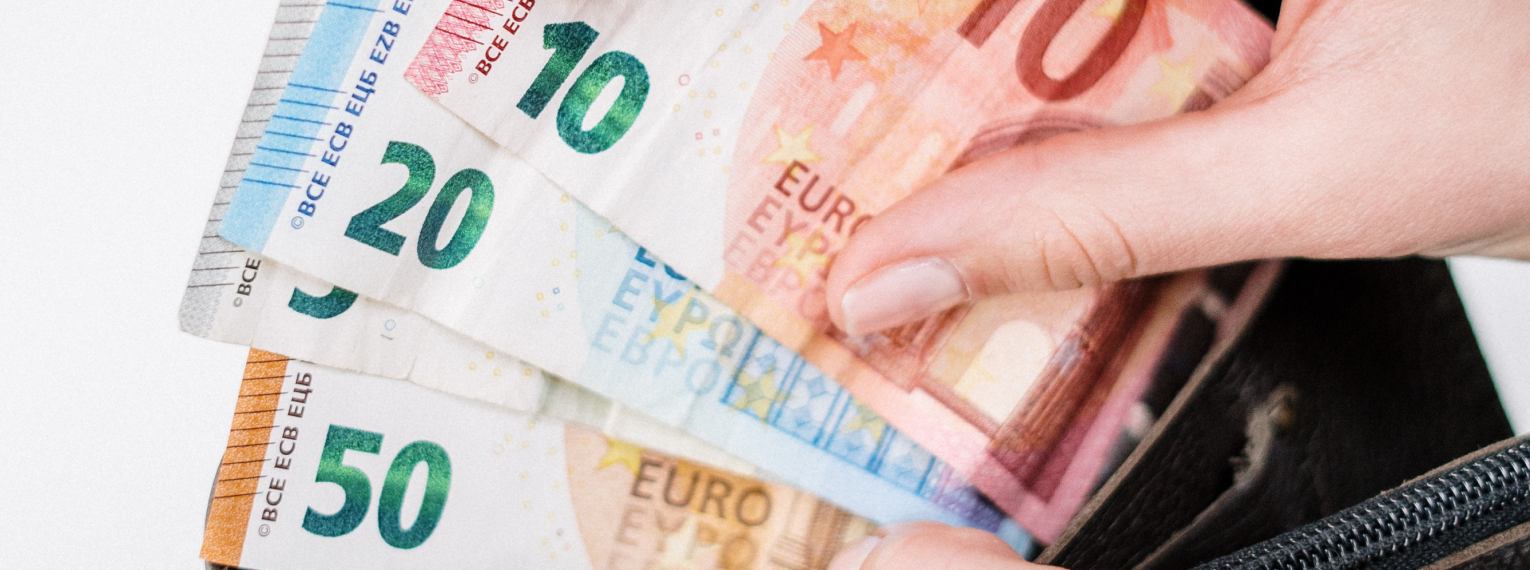 Eine Person zeigt Geldscheine aus ihrem Portemonnaie.