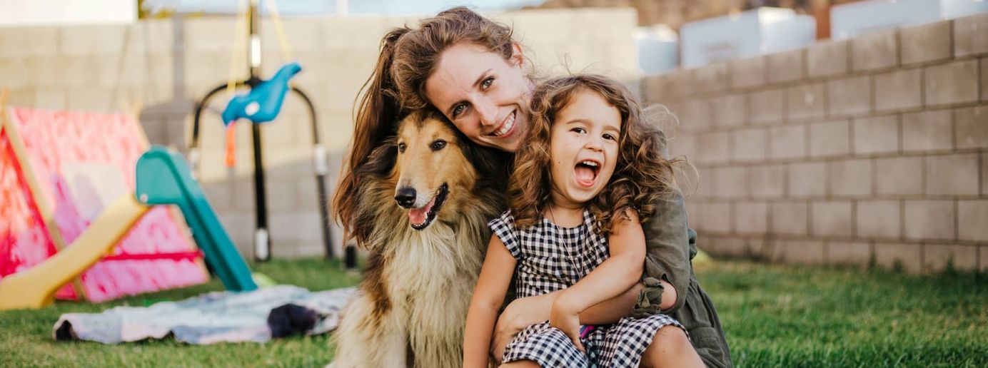 Ein Hund ist mit seiner Familie im Garten.