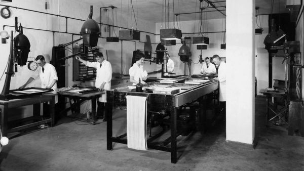 Workers on a factory floor in black and white