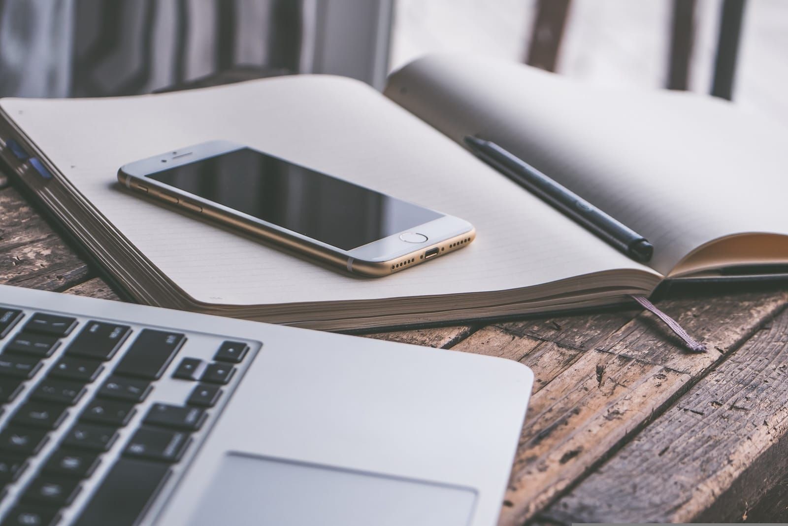 computer and phone and notepad on a desk