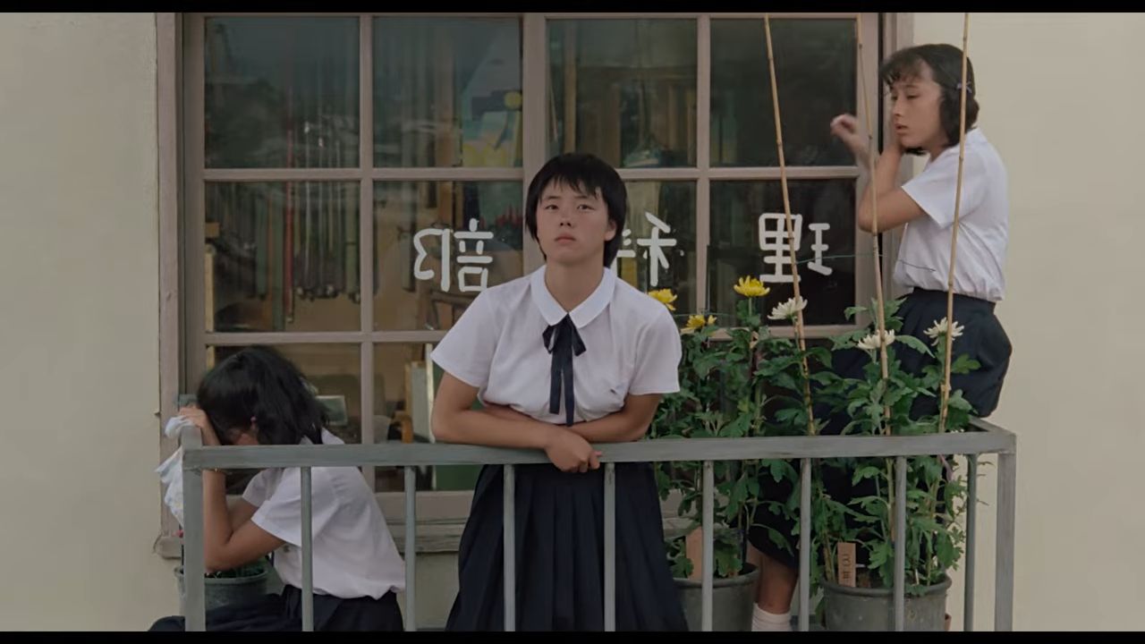 three girls on balcony with flowers