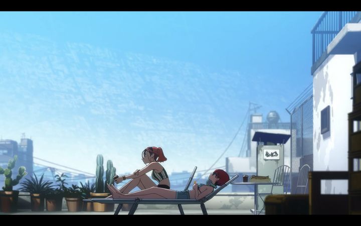 woman and high school girl in summer clothes sit and lie in reclining chairs on weathered rooftop. there are cacti to their left, and buildings can be seen in the sky.