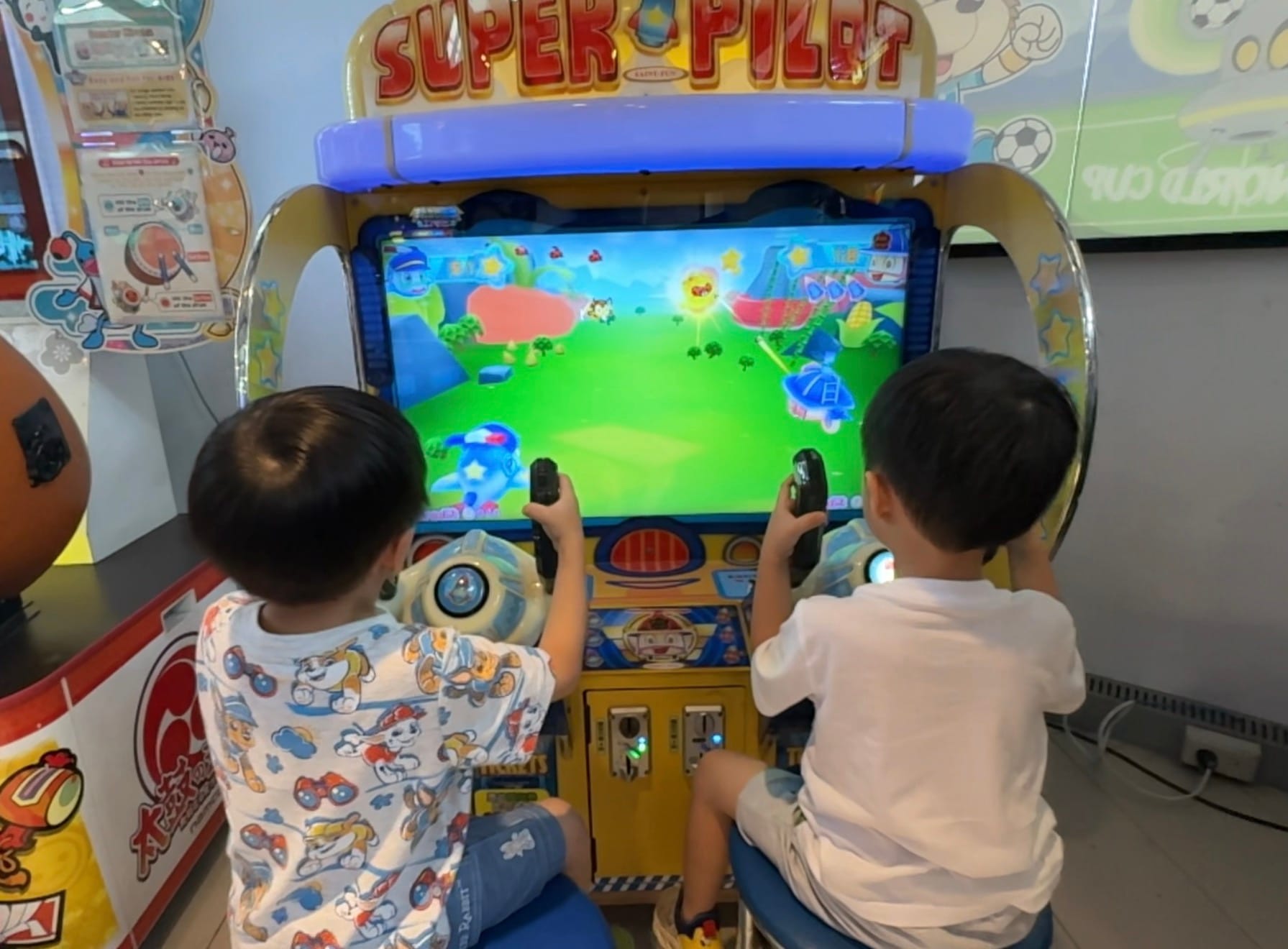 兩名孩子背對鏡頭操作遊戲機