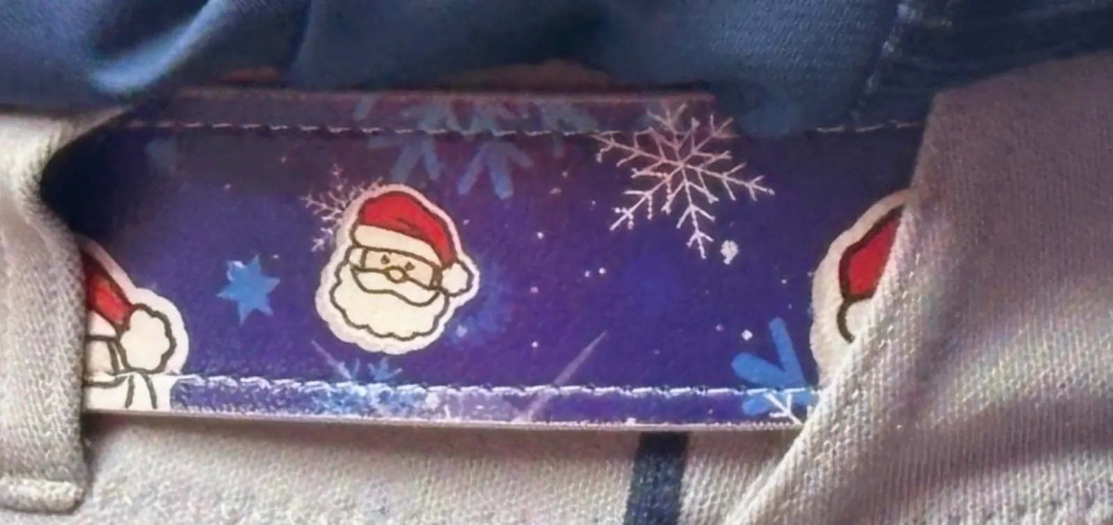 Close-up of Alimber Santa's belt, which is blue with snowflakes and little Santa Claus faces on it.