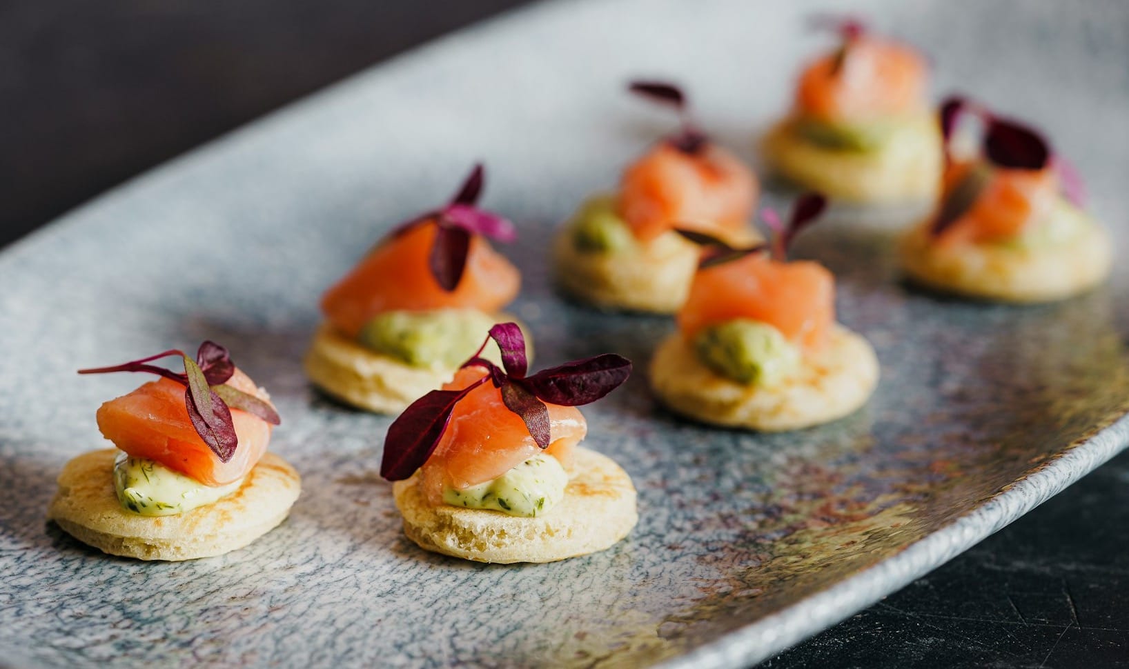 small appetizers are arranged on a silver plate