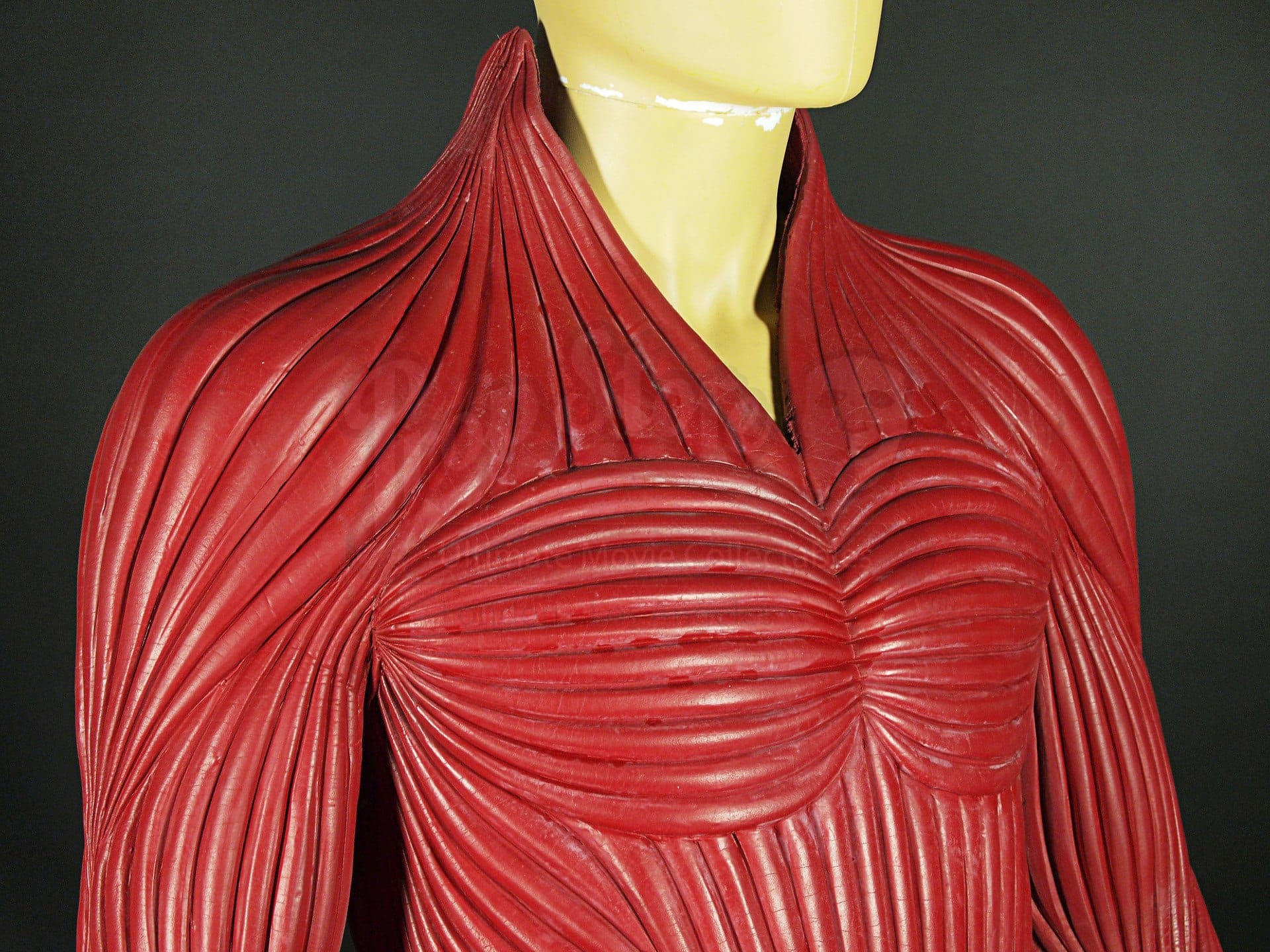 Red molded costume from The Cell designed by Eiko Ishioka, shaped with ridges to resemble striated muscle across chest and shoulders.