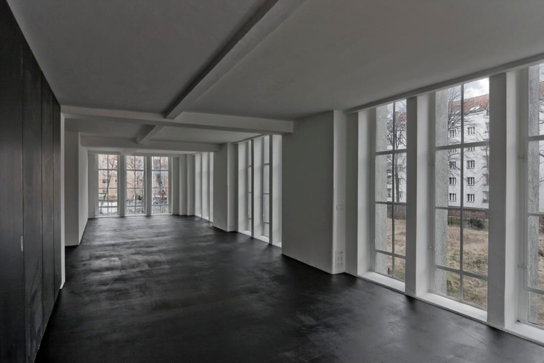 Long upper room with dark floor and windows along one side inside the converted Neukölln pumping station.